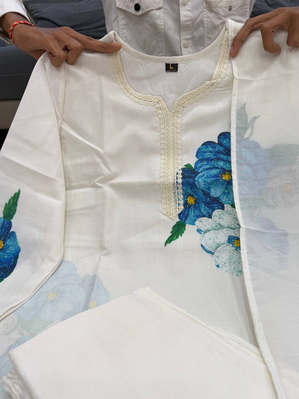 White shirt with floral embroidery held by a person