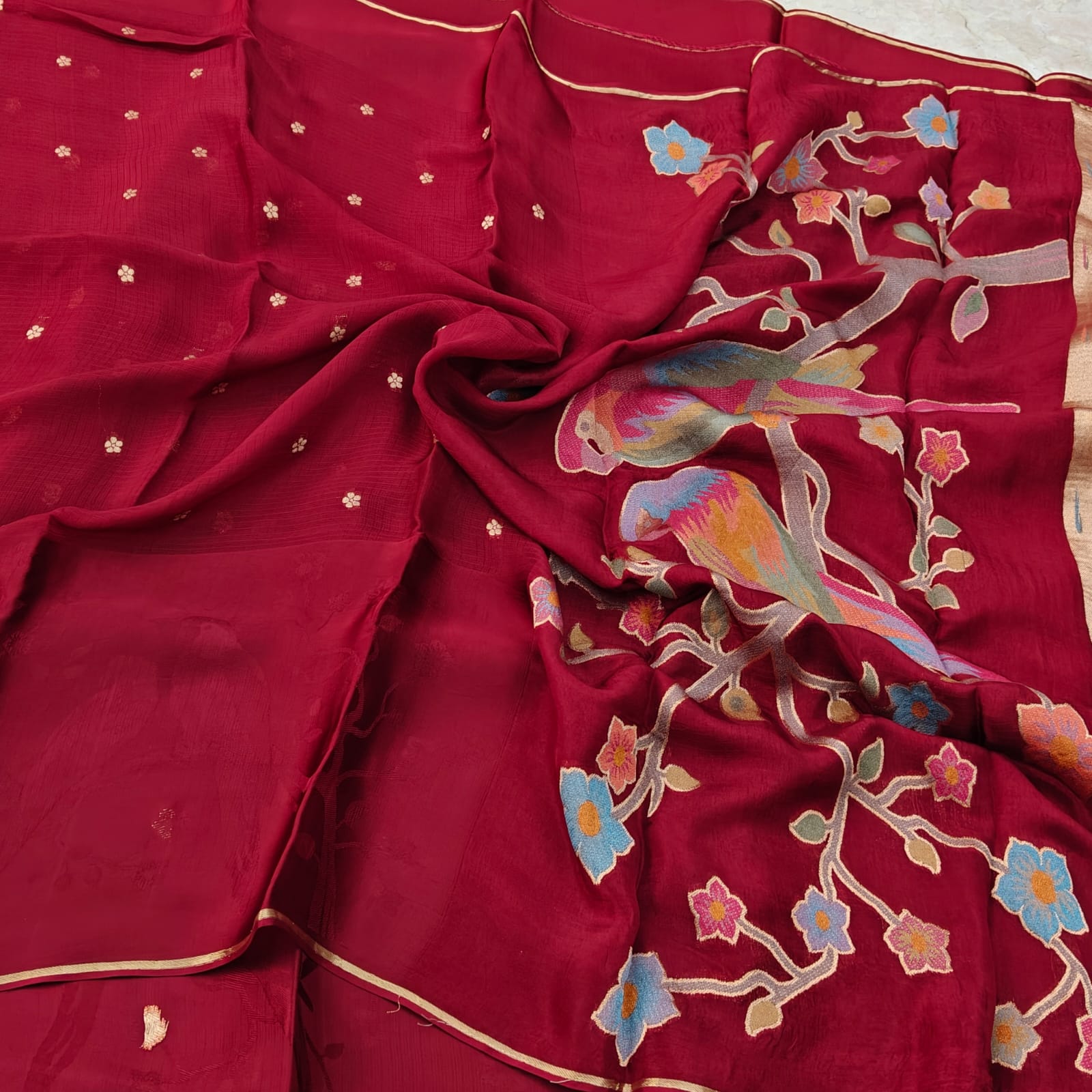 Pink fabric with colorful parrot and floral patterns