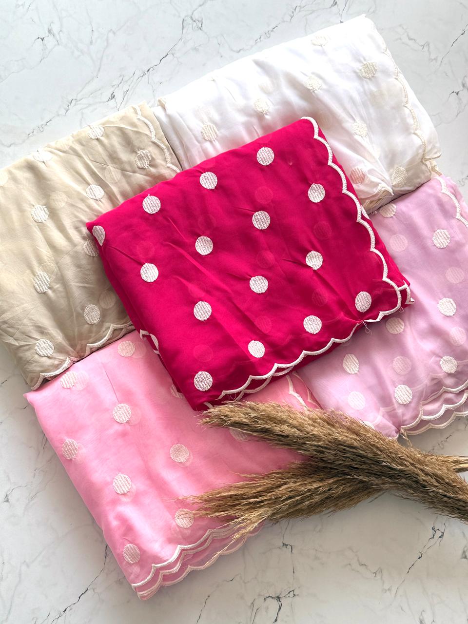 Set of cherry pink with white dots, white with white dots, beige with white dots, baby pink with white dots, lavender with white dots on a light surface.