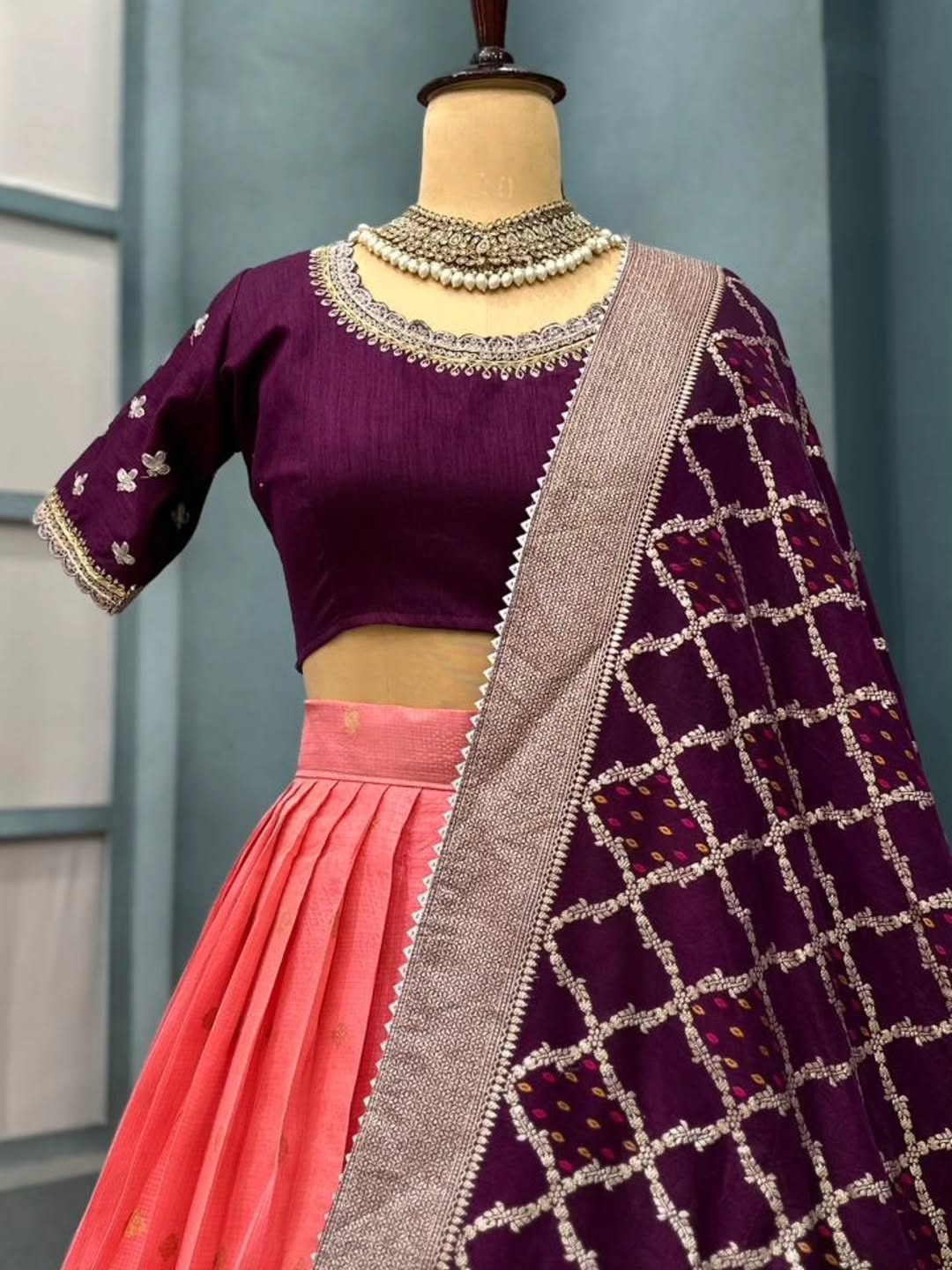 Peach lehanga on a mannequin against a neutral background