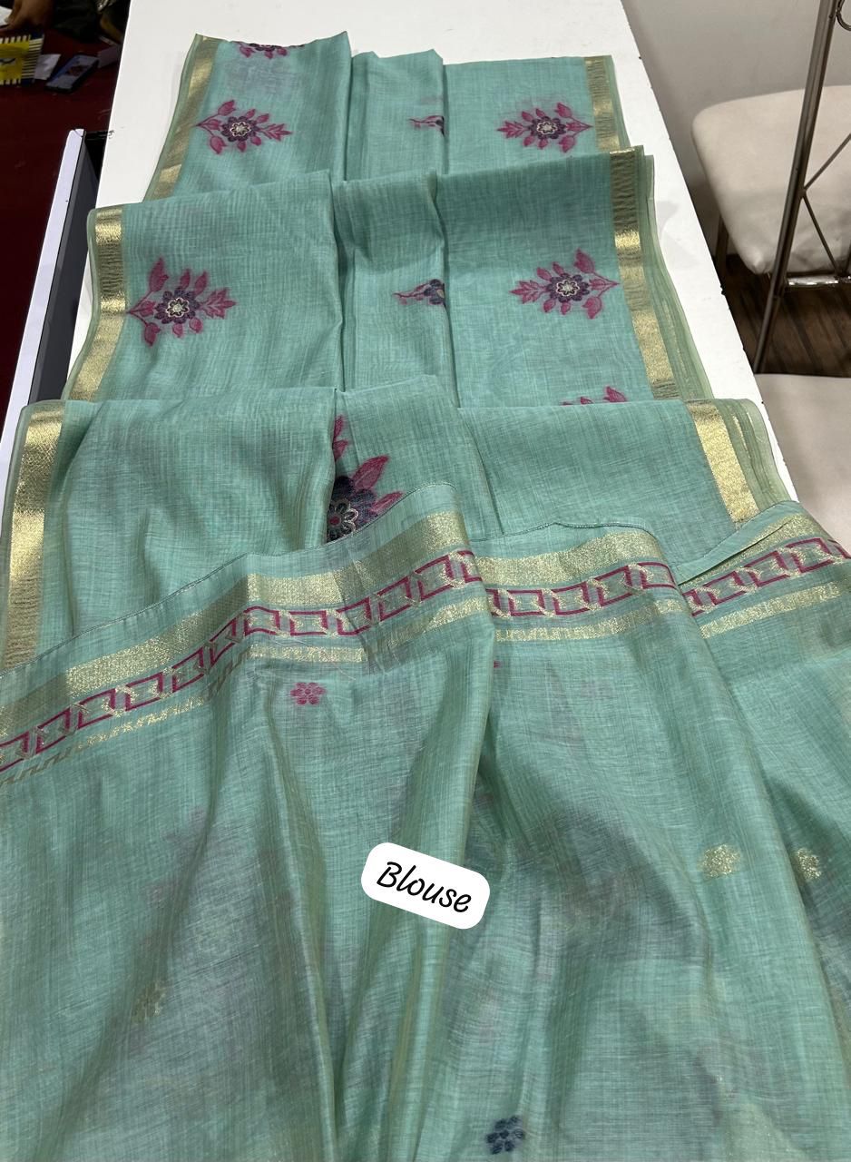 Teal blue saree with floral patterns on a white surface