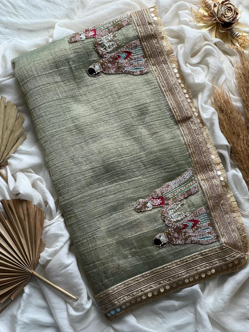 Light Green saree with border and floral patterns on a white fabric background