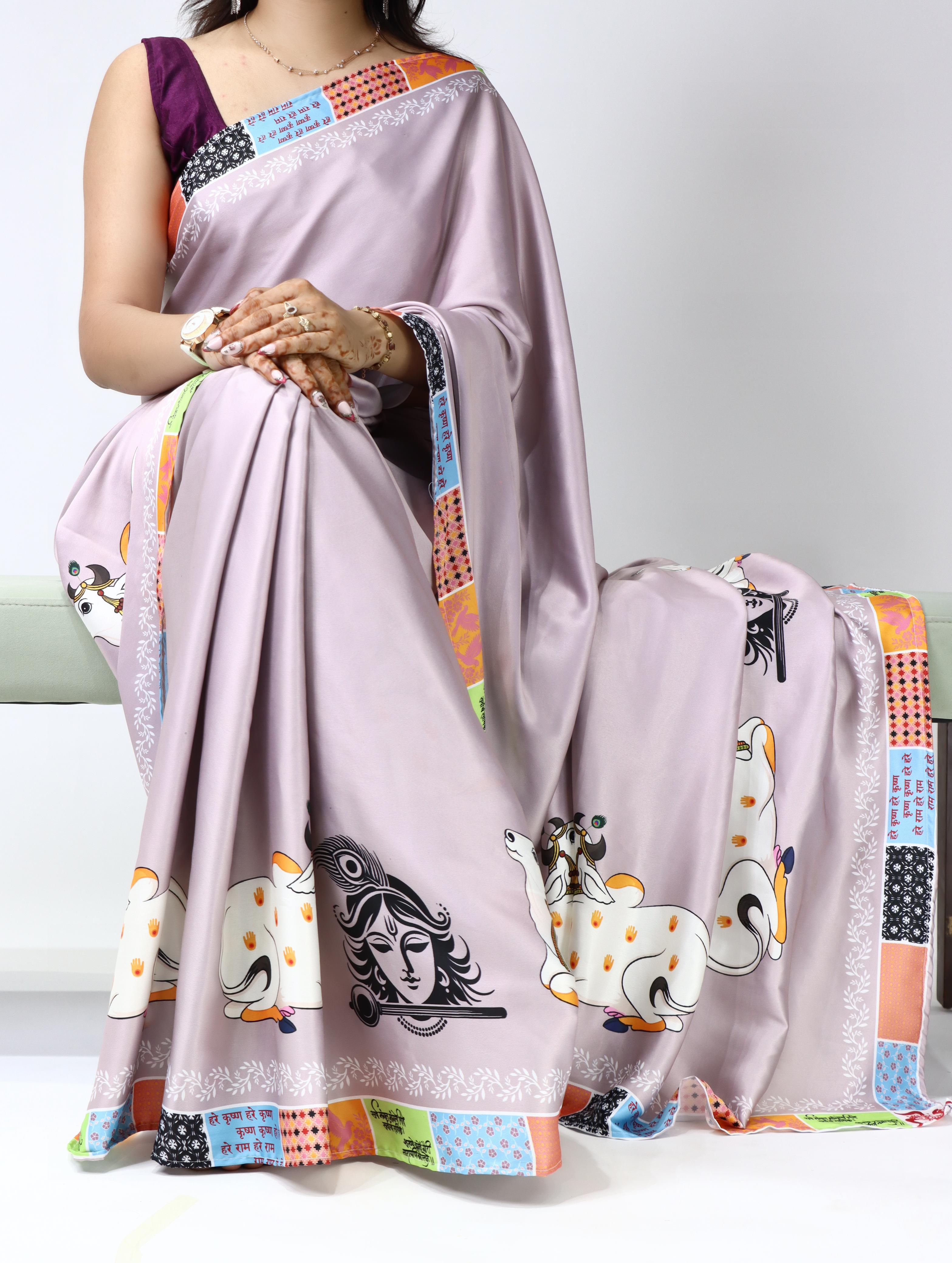 Person wearing a light purple saree with colorful patterns on a white background