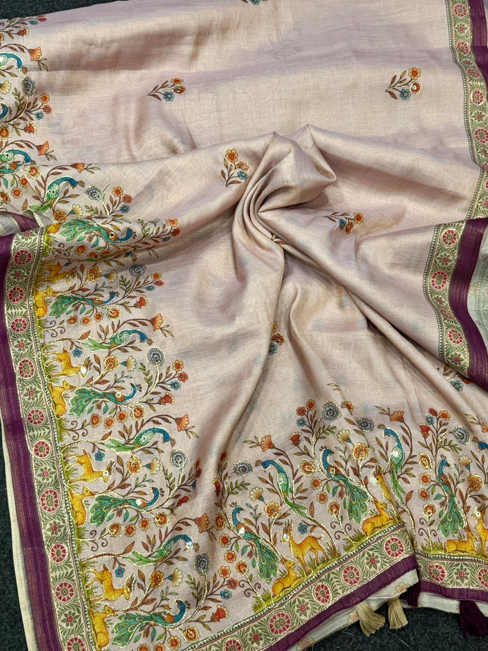 Beige fabric with intricate patterns and colors on a plain background