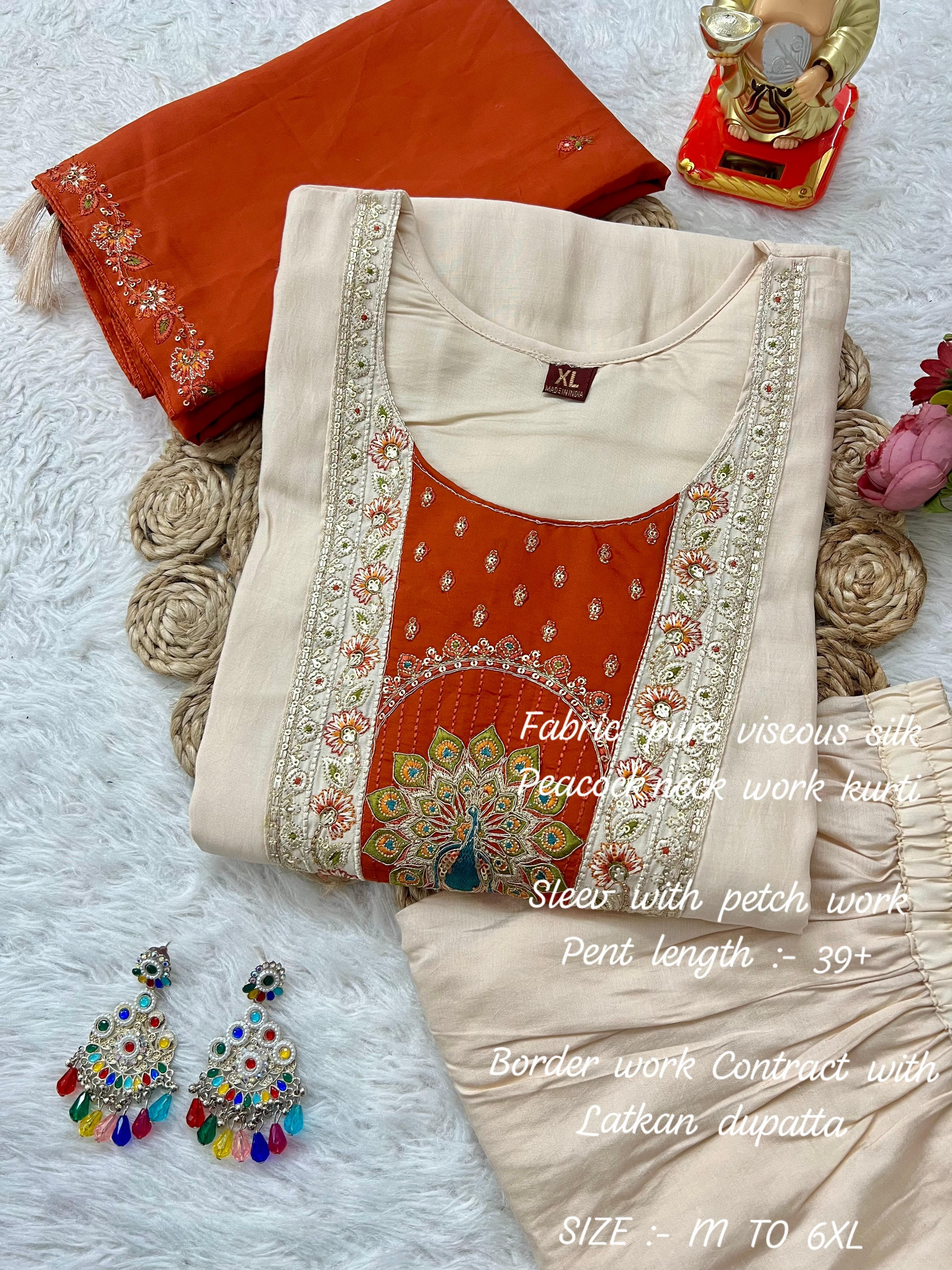 Orange fabric with embroidery, earrings, and decorative items on a texture surface.