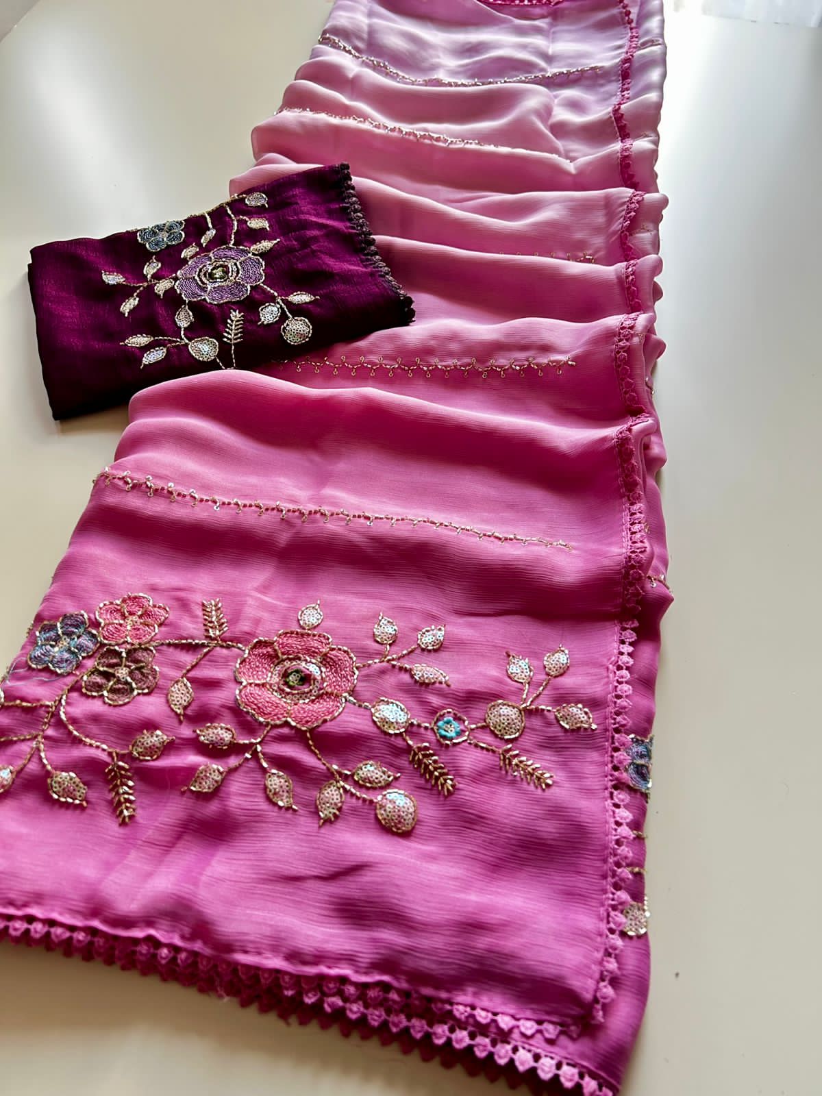 Baby Pink saree with floral embroidery and a purple blouse on a white background