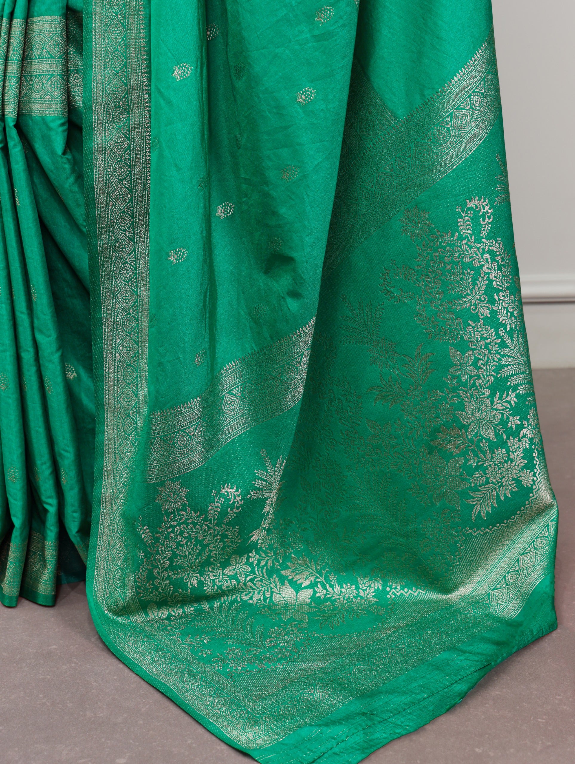 Cyan saree with intricate patterns on a plain background