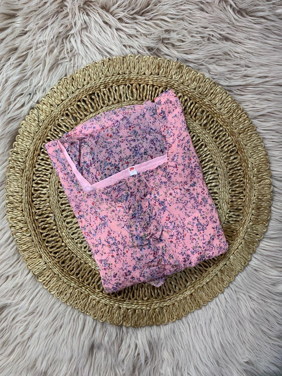 Baby Pink floral dress on a woven mat with a fluffy gray background