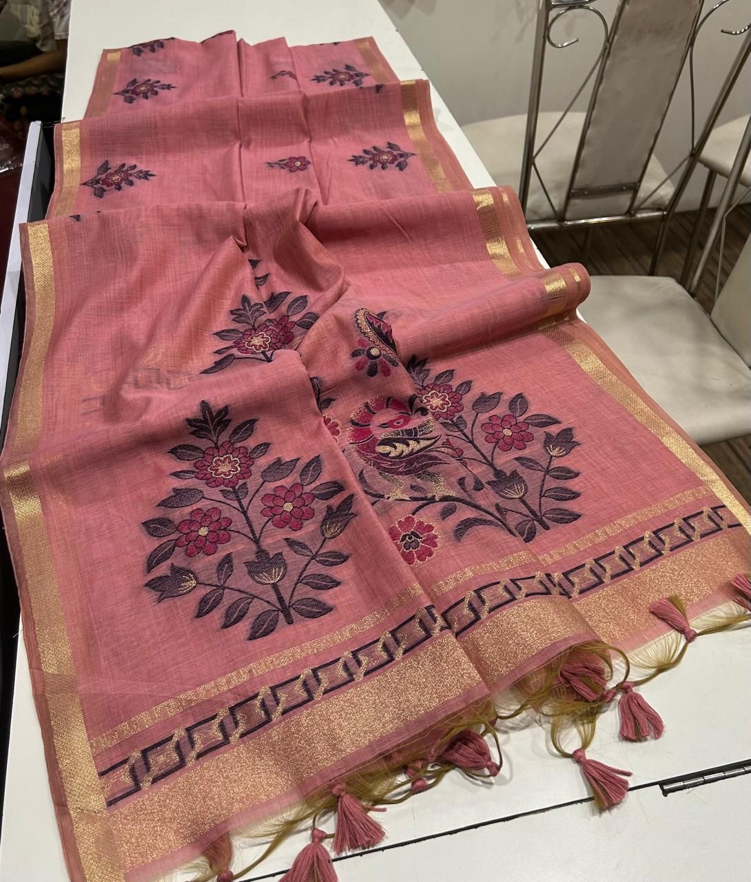 Light pink saree with floral patterns on a white table