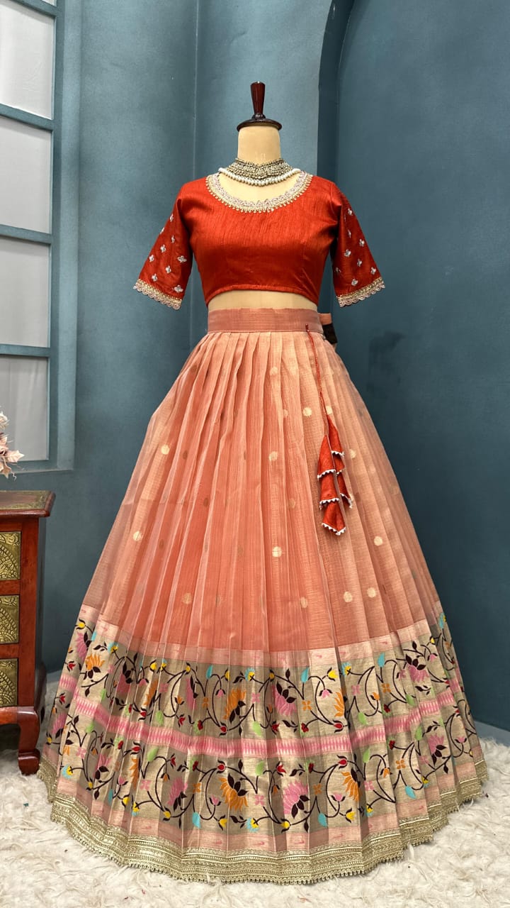Light orange lehenga on a mannequin against a blue wall.