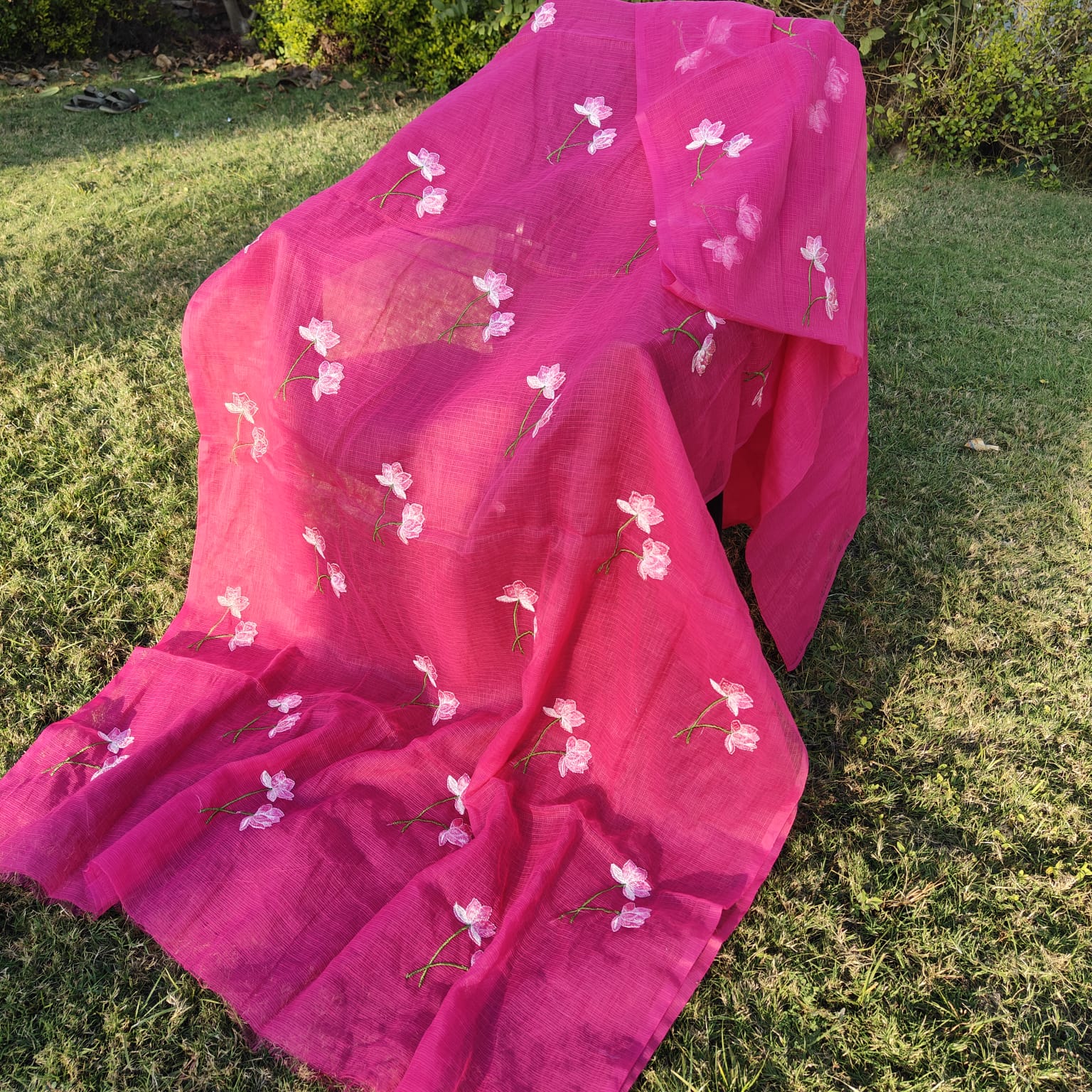 Bright Pink saree with floral patterns on a grassy background