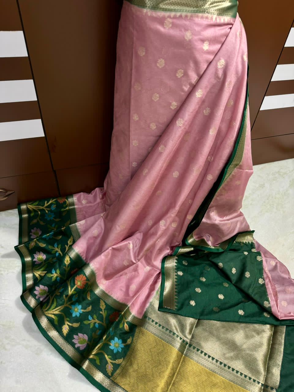 Baby pink saree with floral patterns on a white surface