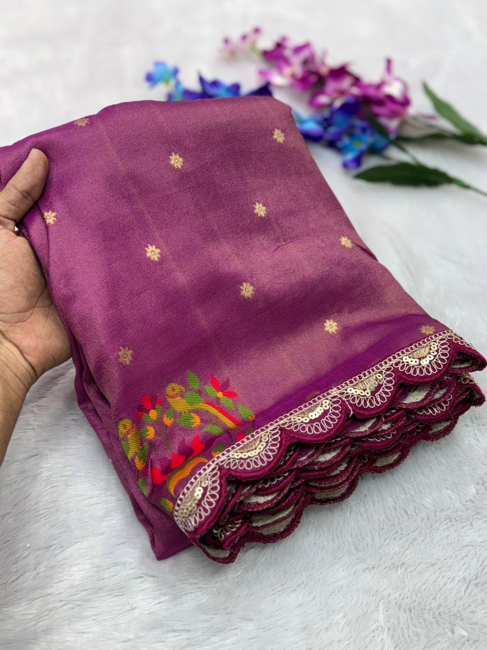 Wine fabric with floral embroidery held by a hand on a light gray background