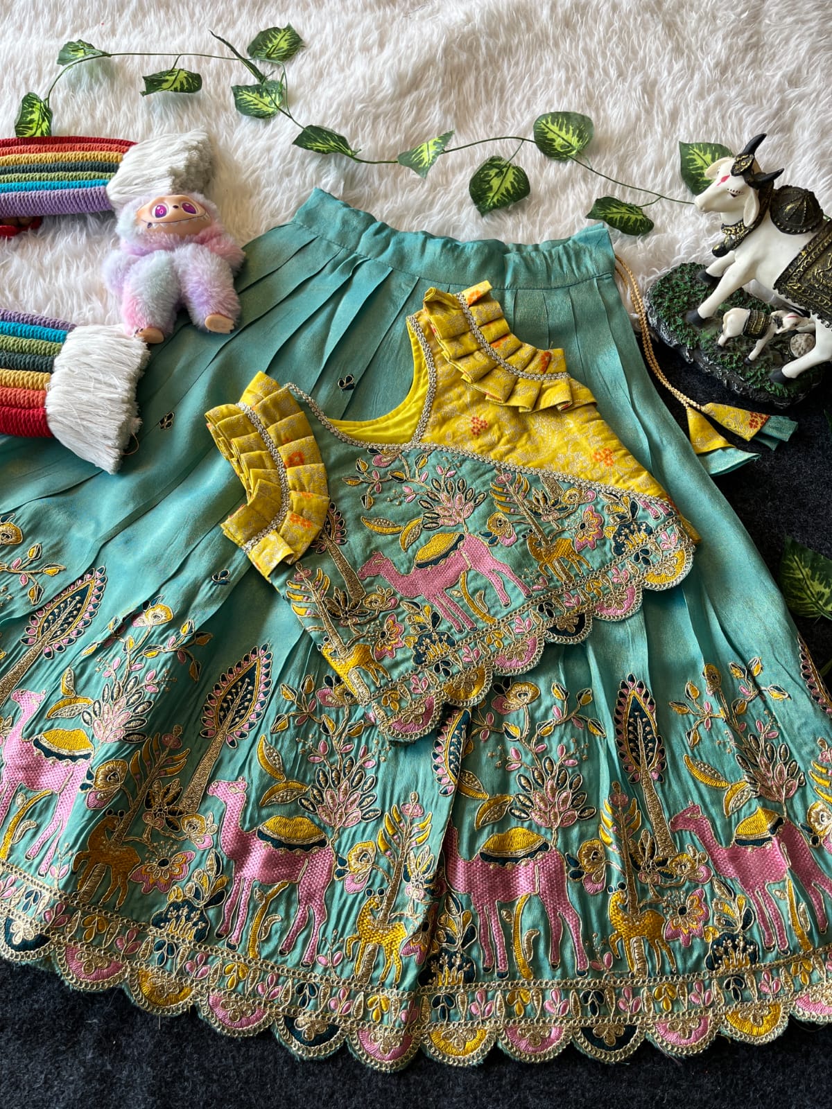 Cyan Embroiderey skirt with colorful designs on a textured surface with decorative items.