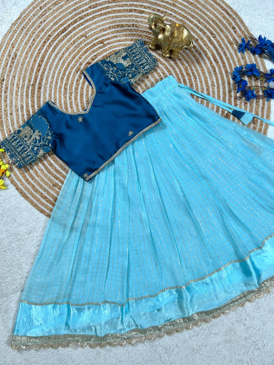  embroidere blouse and Sky Blue skirt on a texture surface with decorative elements.