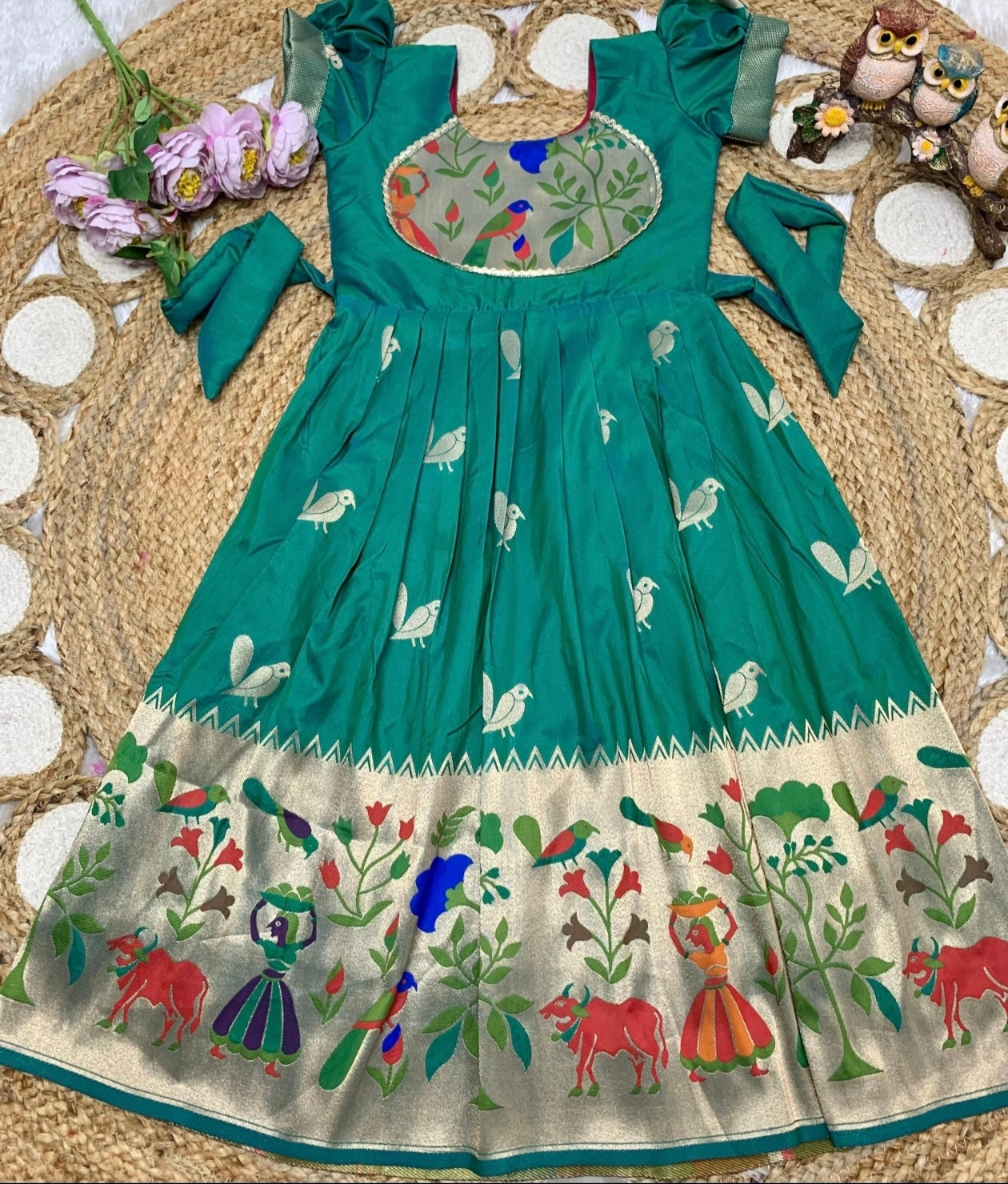 Rama Green and embroidery dress with floral and animal patterns on a texture surface.