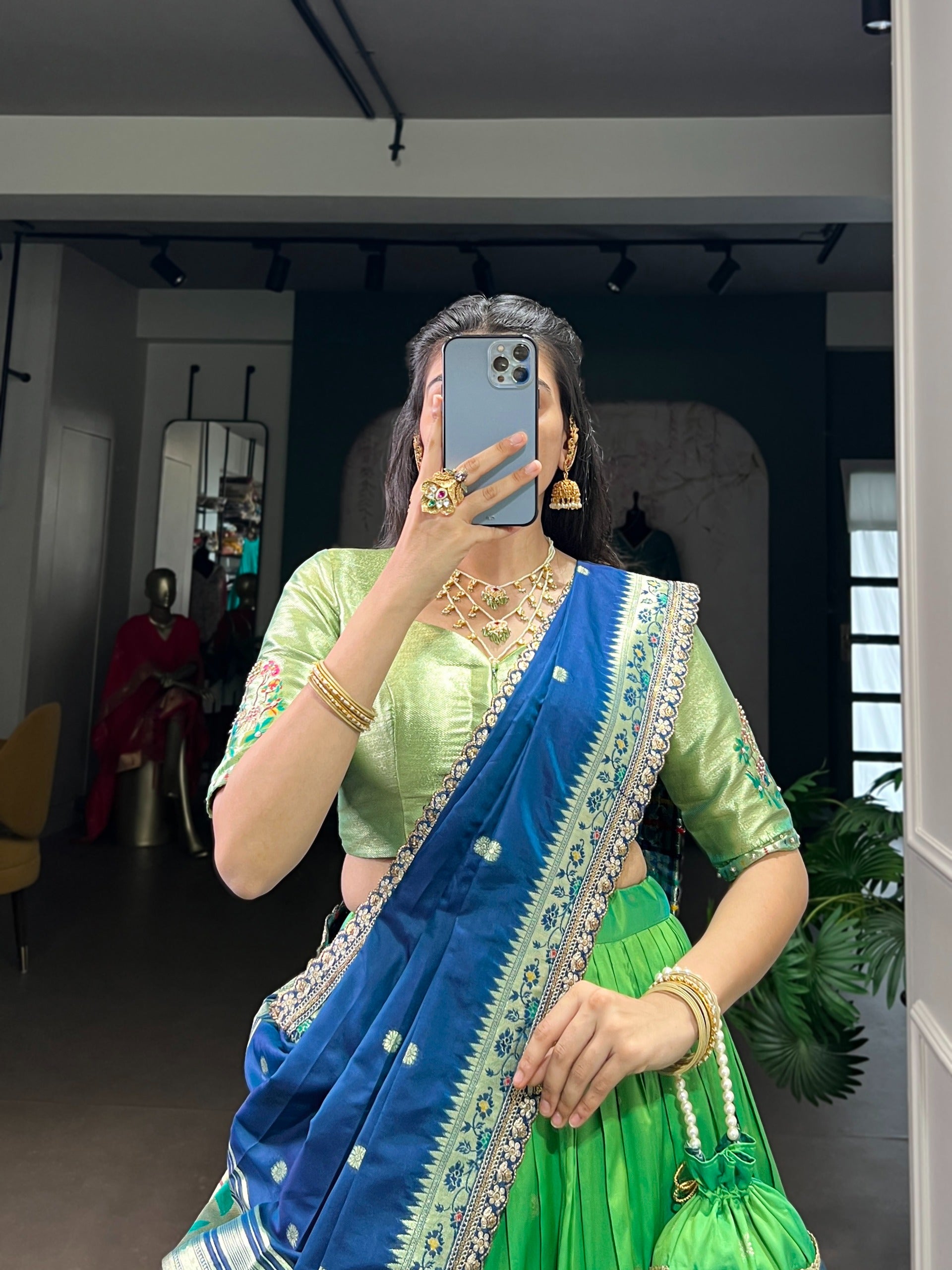 Parrot green saree with jewelry indoors.