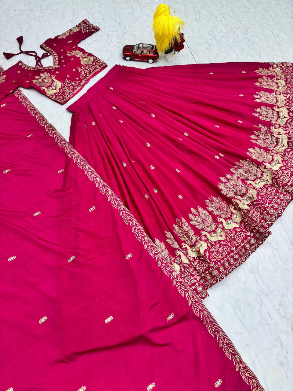 Pink saree with gold embroidery on a white background