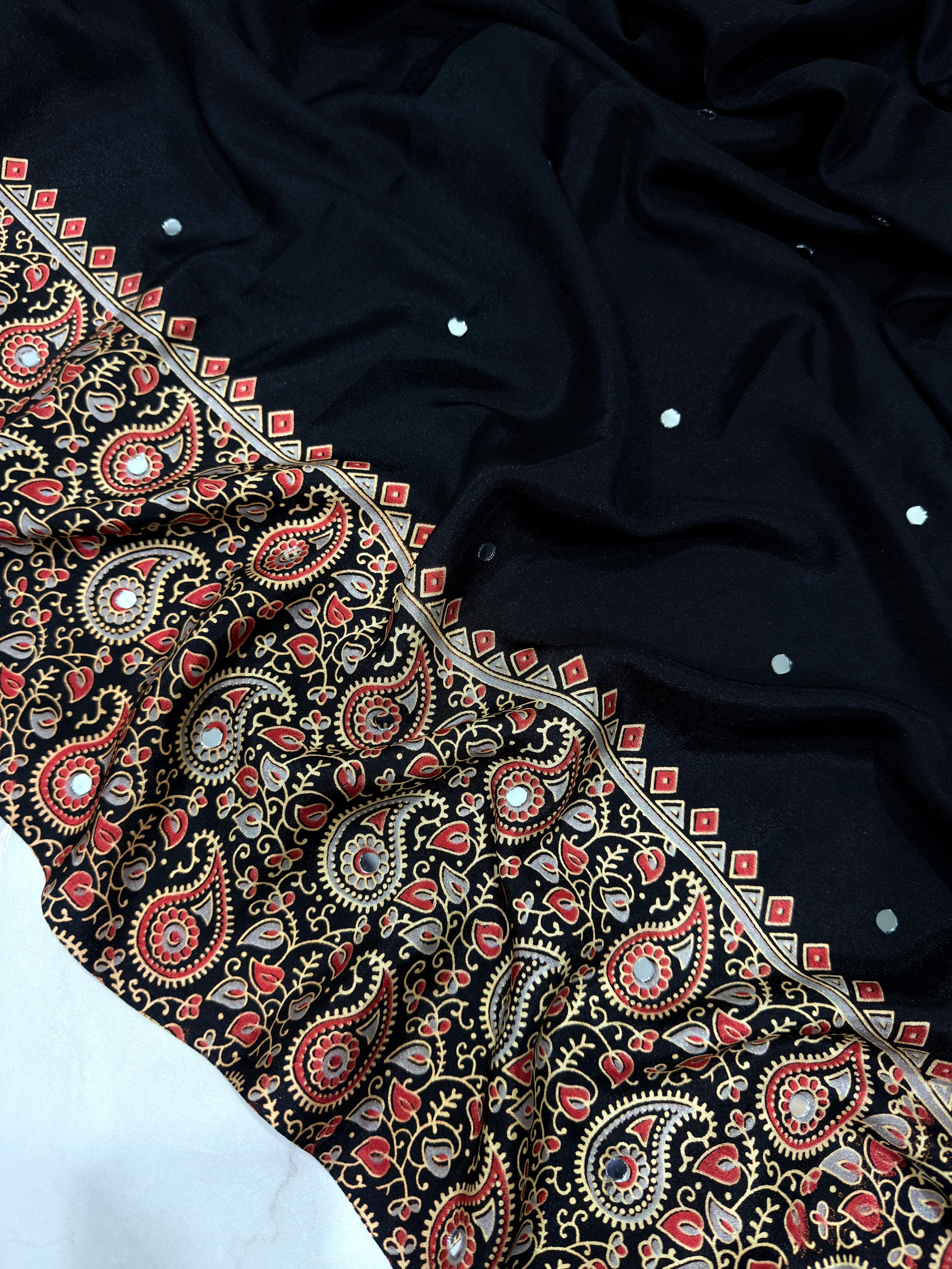 Black fabric with intricate red and gold paisley patterns