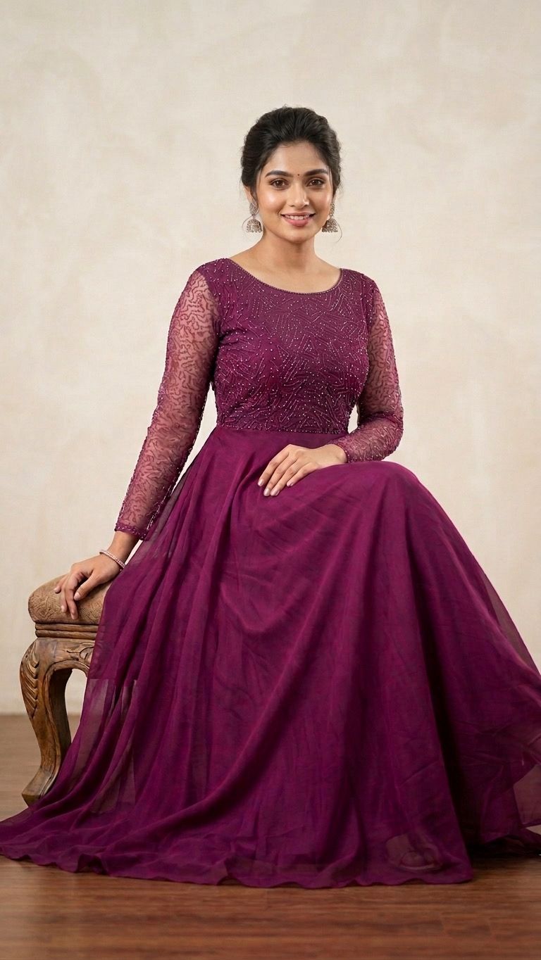 Woman wearing a magenta gown with long sleeves against a beige background