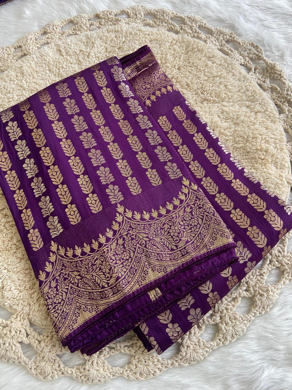 Purple fabric with gold embroidery on a texture surface