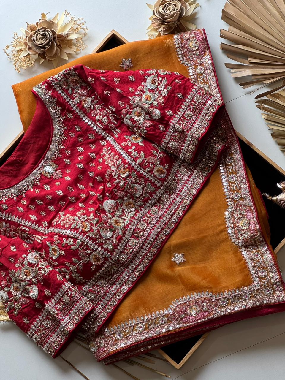 Red and Mustard Yellow embroidered fabric with gold accents on a white surface.