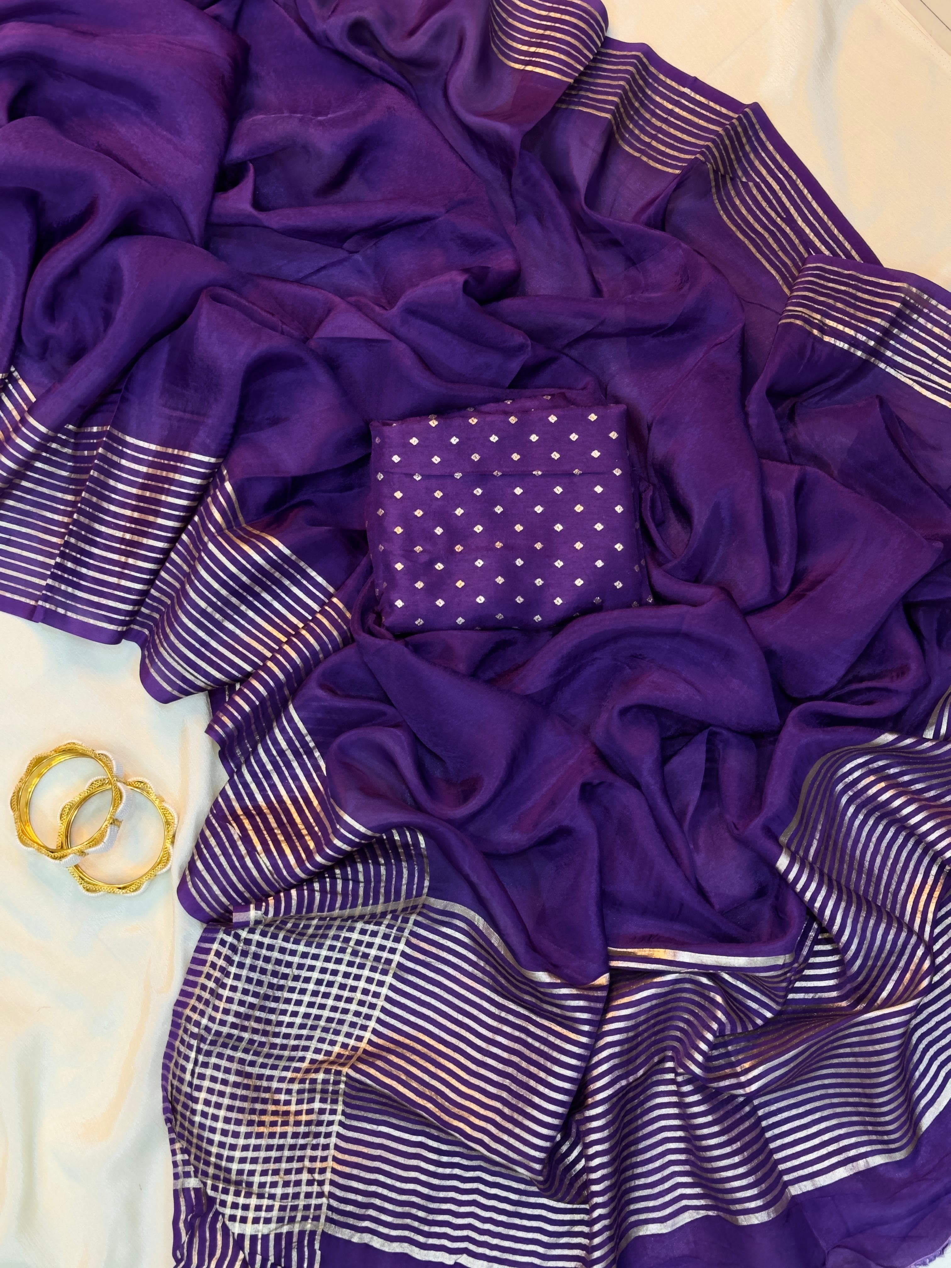 Purple fabric with gold and white patterns on a textured surface