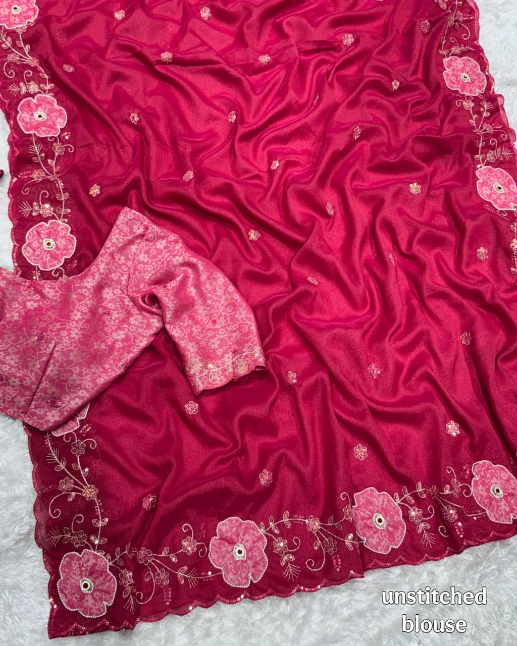 Pink embroidered fabric with floral patterns on a white background