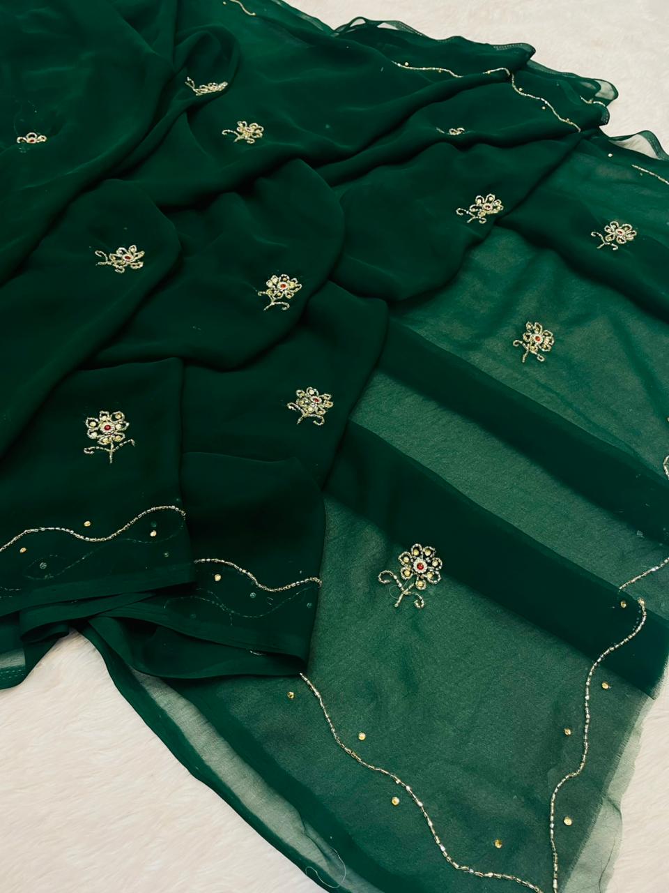 Green fabric with floral embroidery on a light background