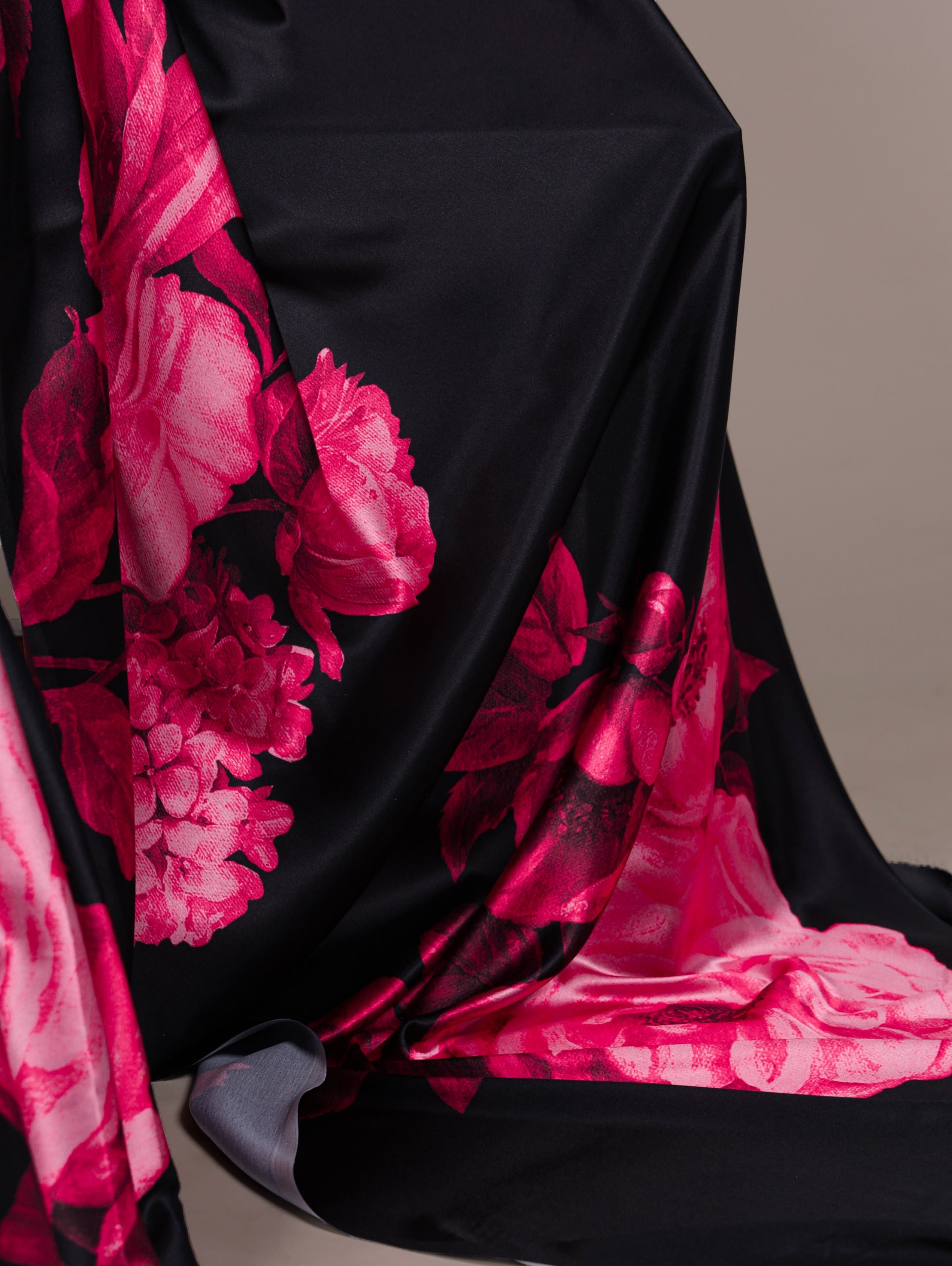 fabric with pink floral patterns draped over a chair.