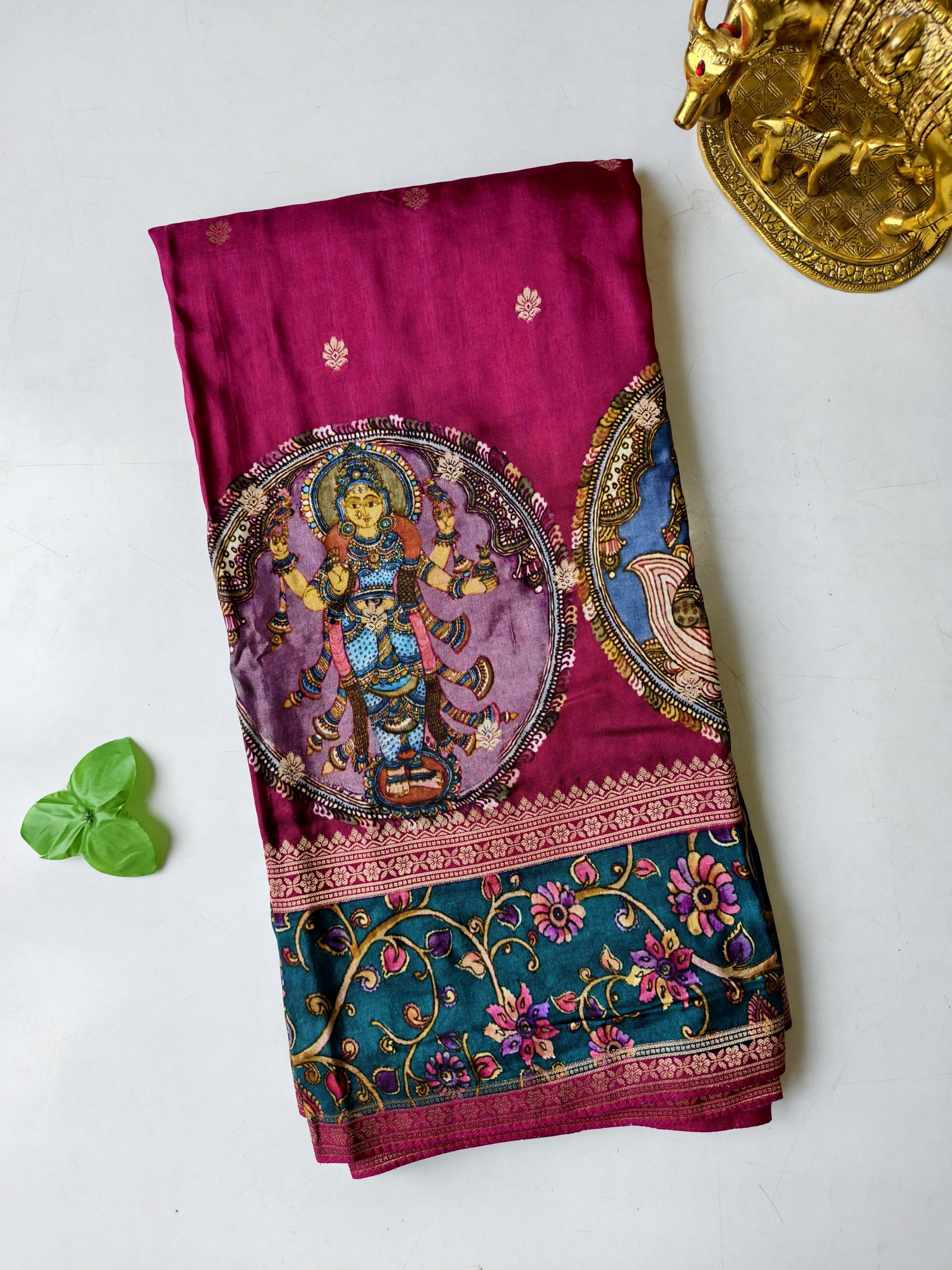 Colorful Rani pink saree with a deity design on a white background