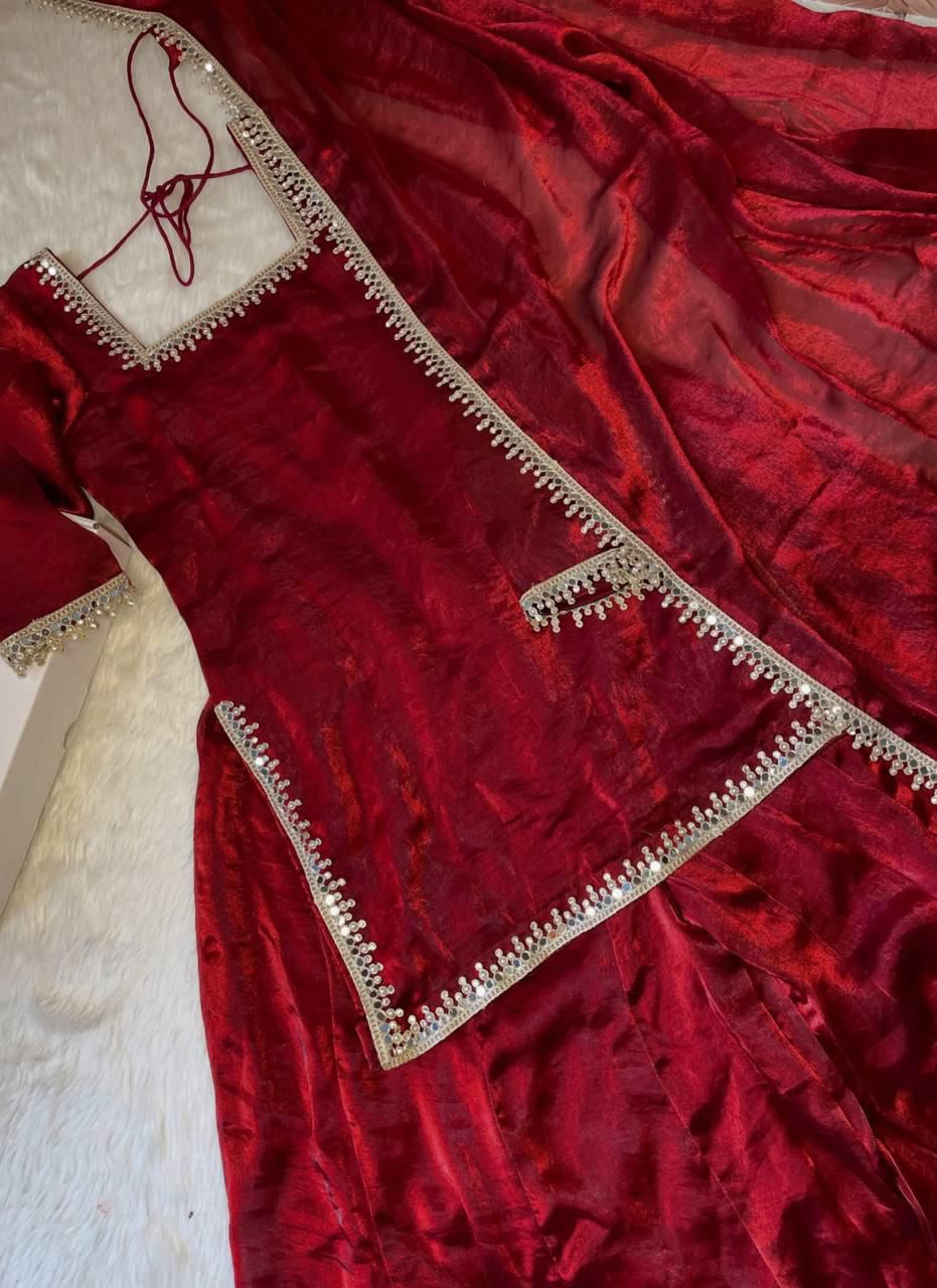 Red velvet garment with intricate gold embroidery on a textured background