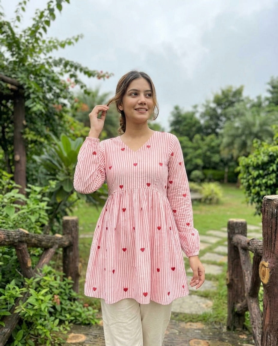 Woman wearing a Baby pink checkered dress with heart patterns in a garden setting