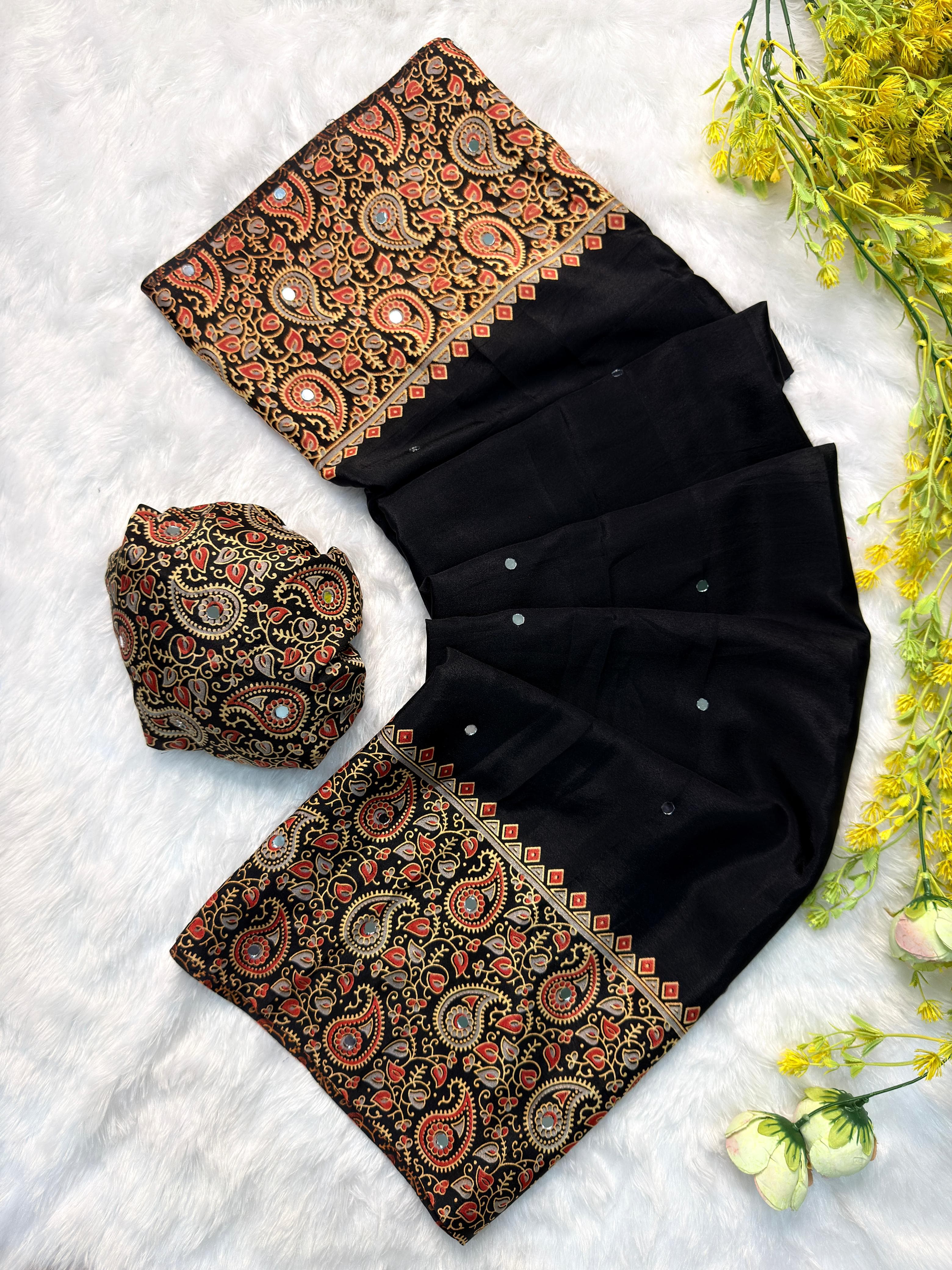 Black saree with patterned pallu on a white background with flowers
