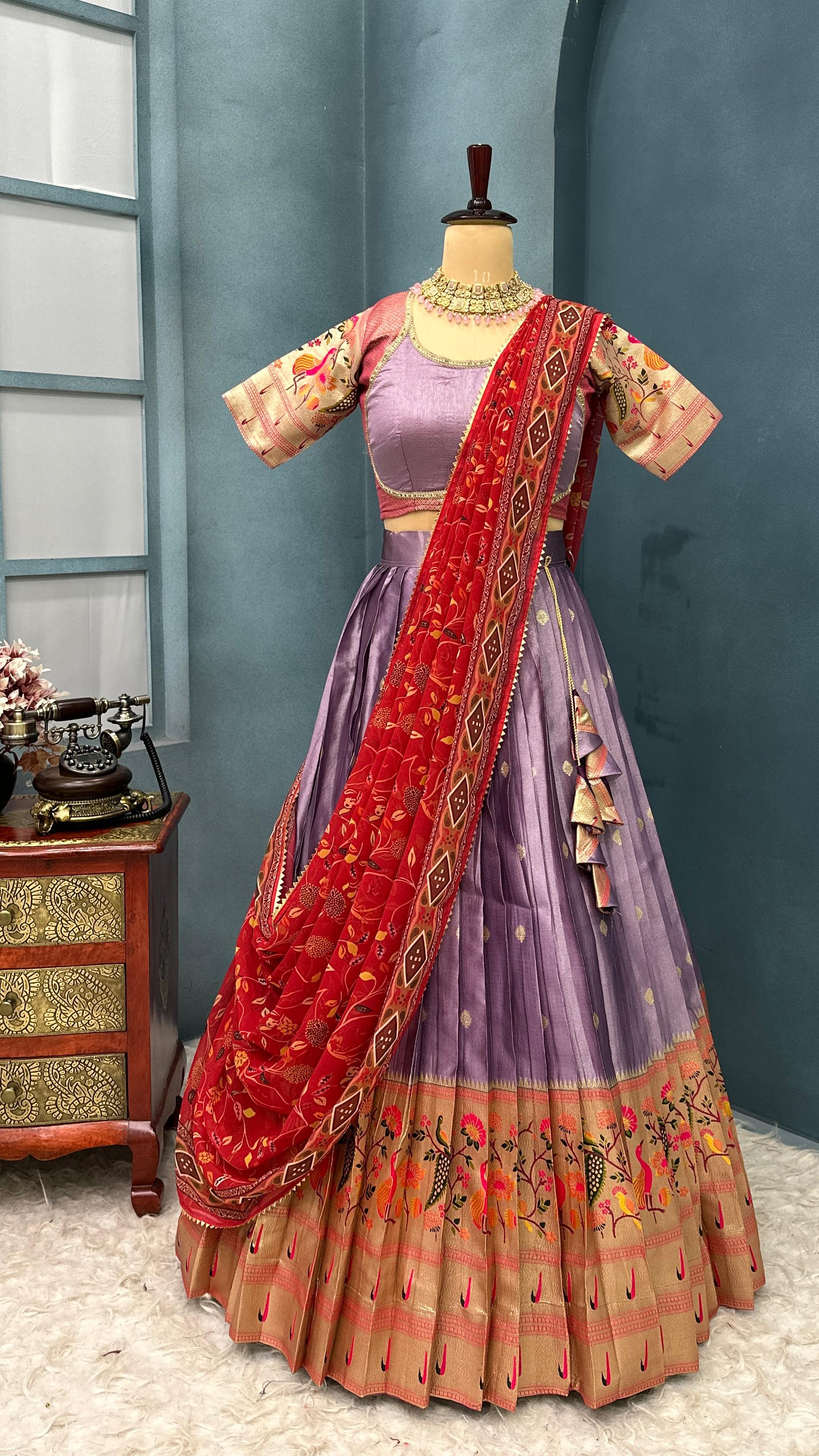 Lavender with Red Traditional Indian lehenga with dupatta on a mannequin against a blue wall.