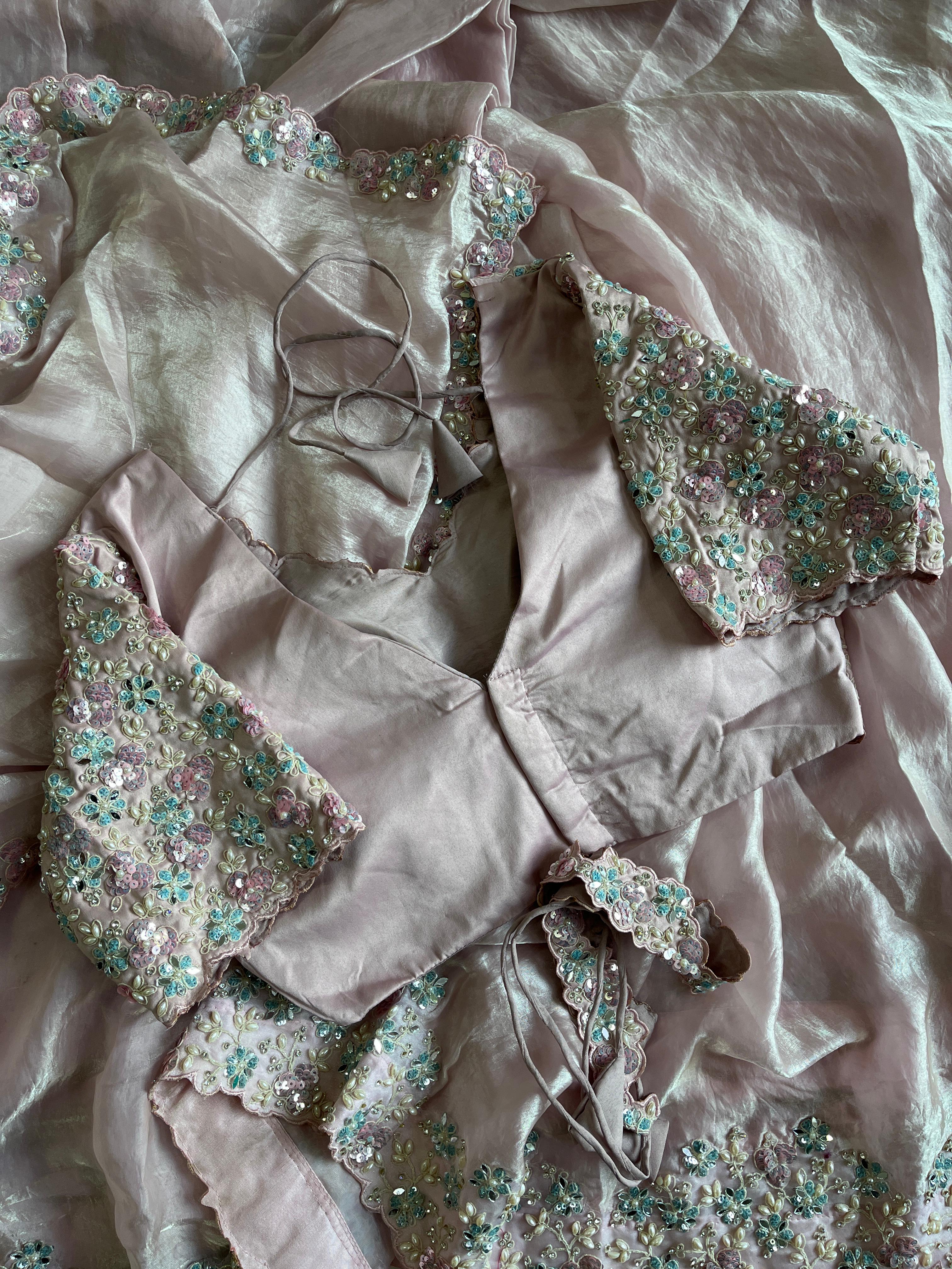 Elegant dress with intricate beadwork on a baby pink fabric background