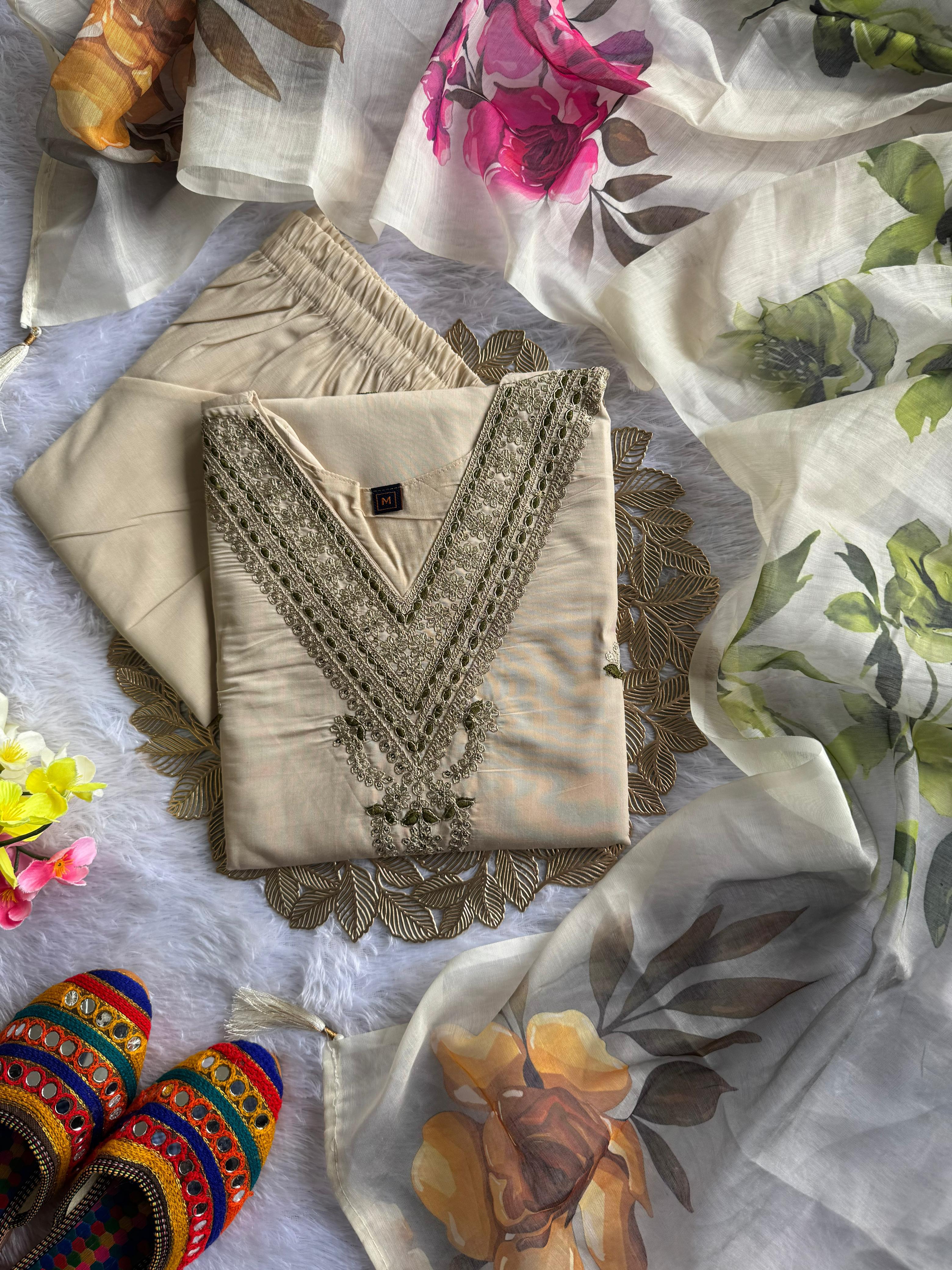 Beige embroidered blouse with floral fabric and colorful sandals on a white background