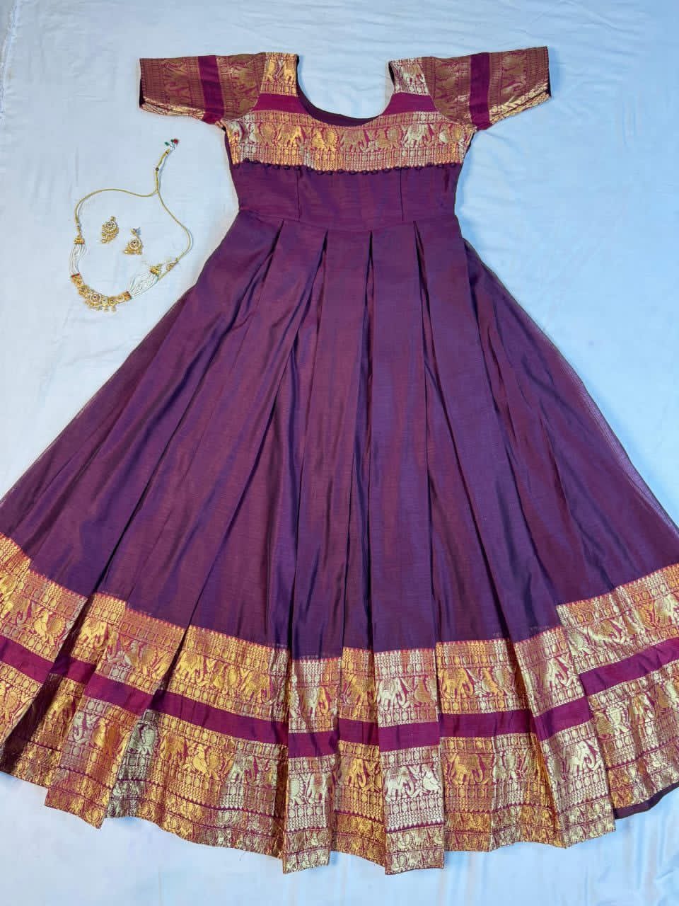 Wine traditional dress with gold accents on a white background