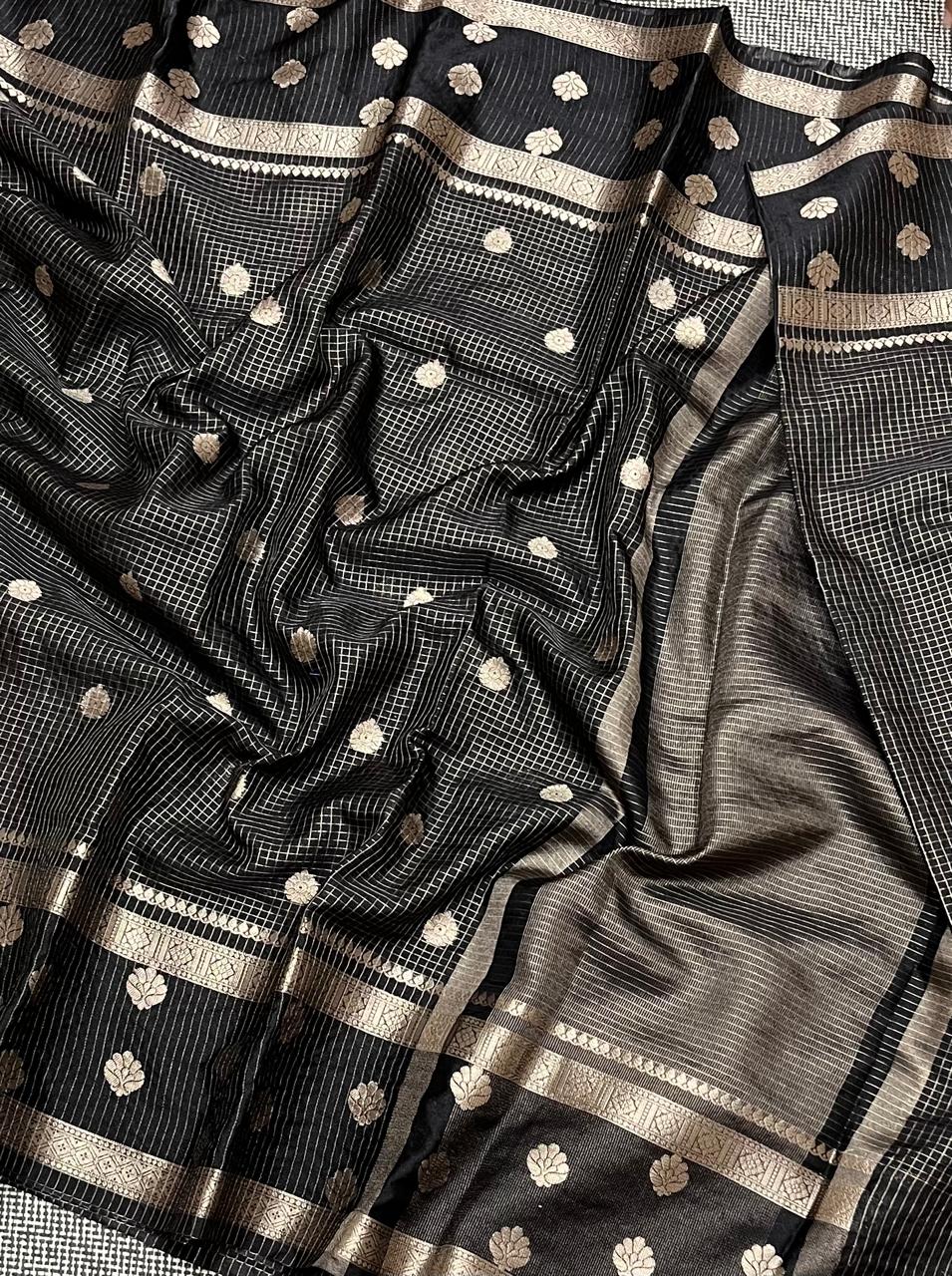 Black saree with gold patterns on a texture surface