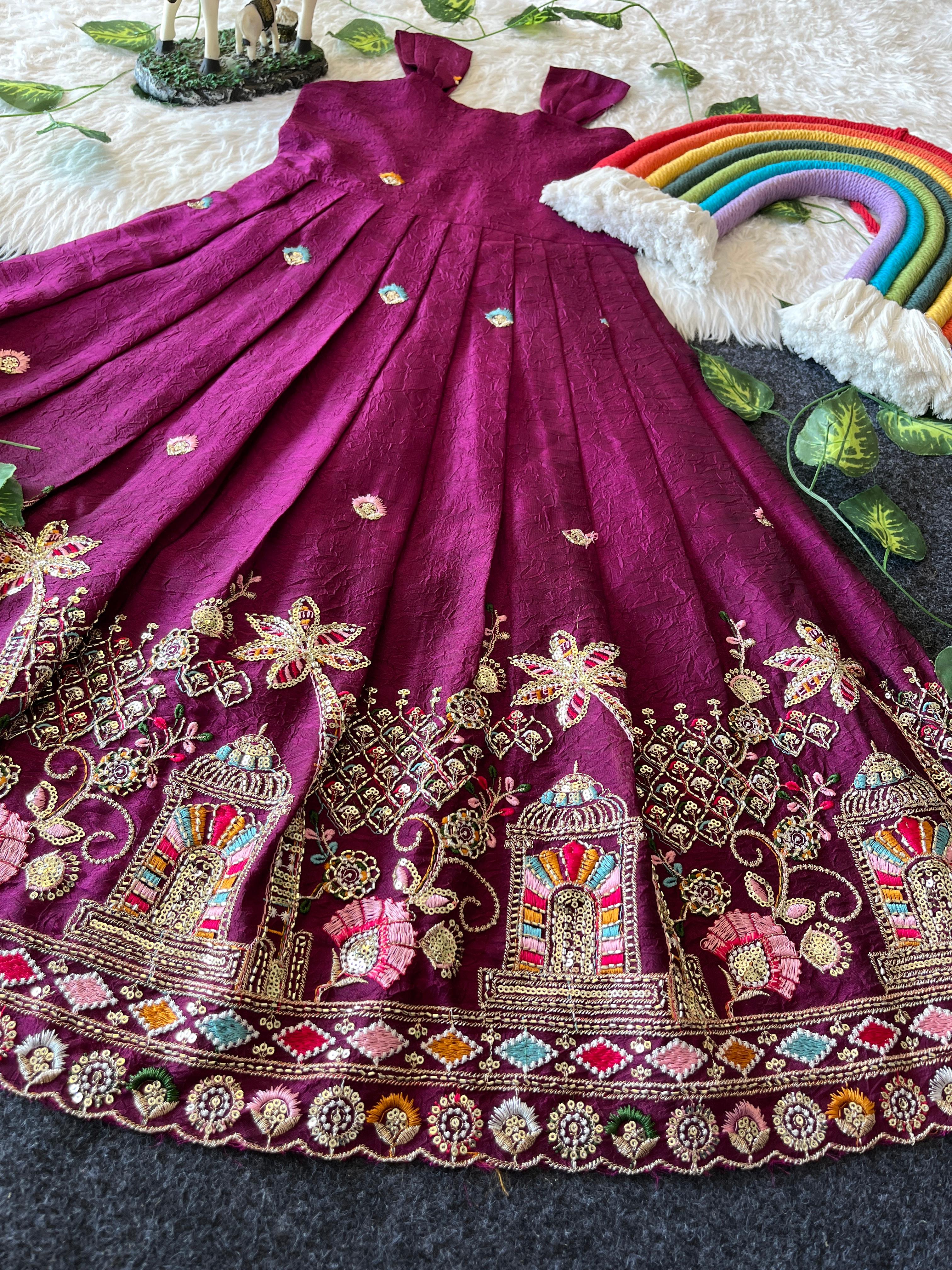 Rani pink embroiderey dress with intricate patterns on a textured surface