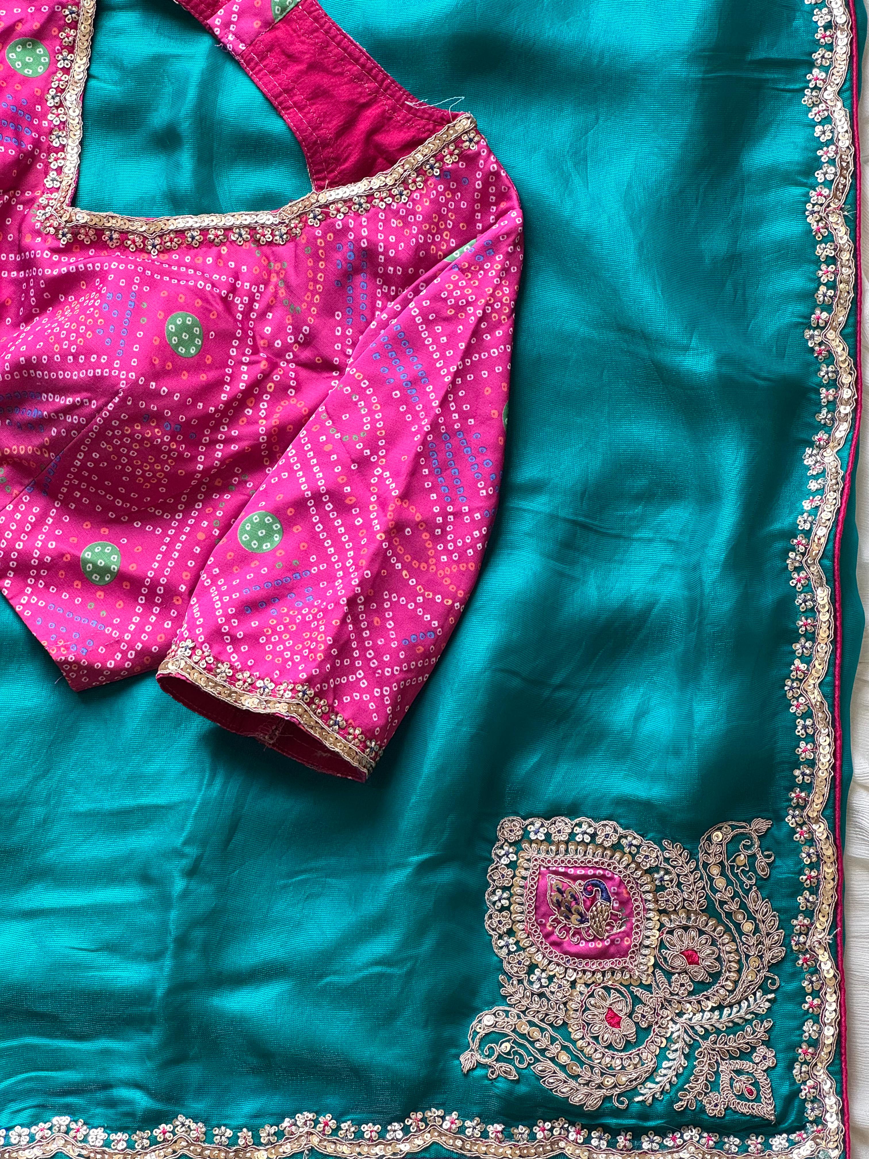 Teal blue saree with pink blouse featuring intricate embroidery
