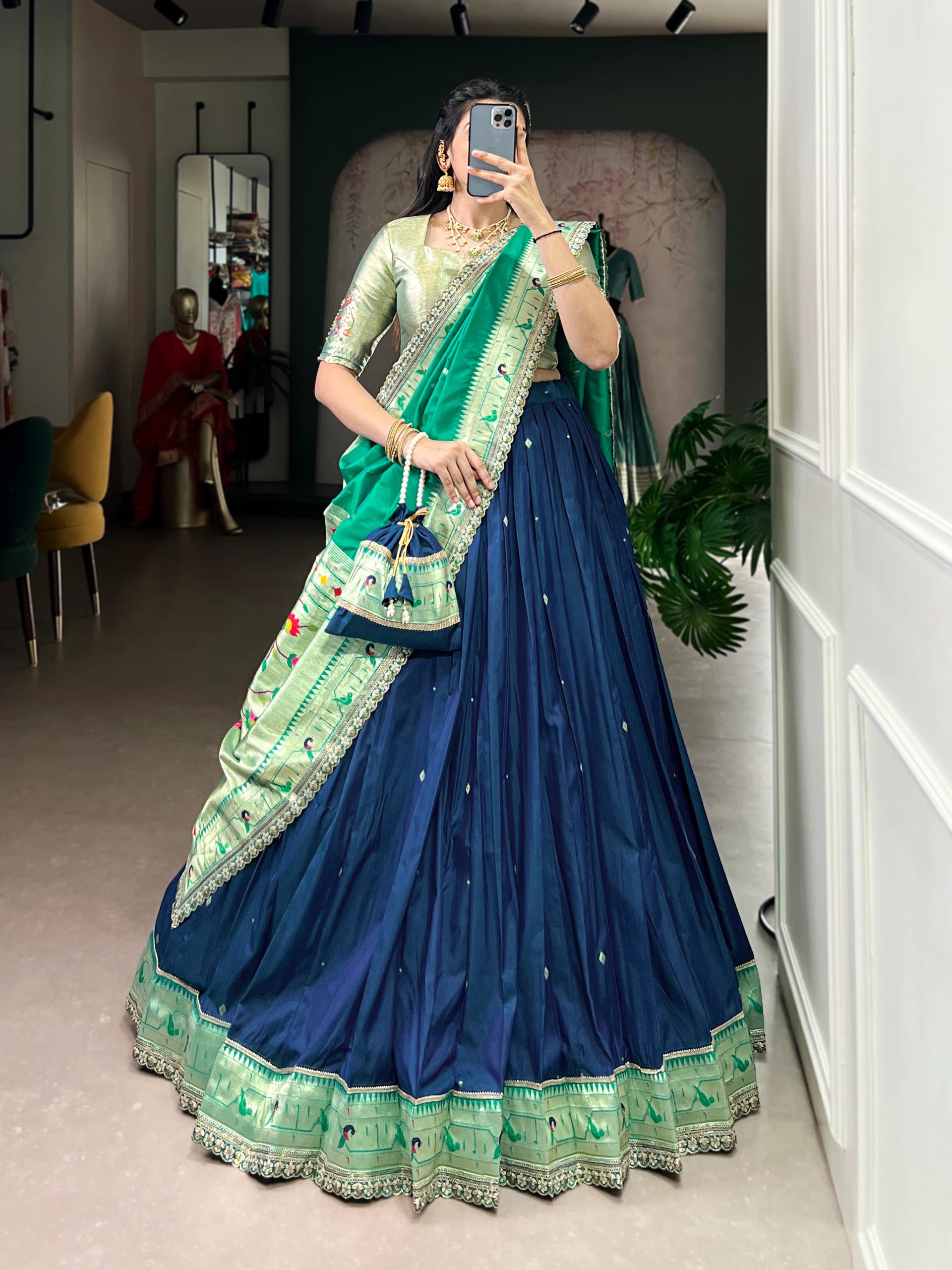 Person wearing a traditional navy blue saree in a room setting.