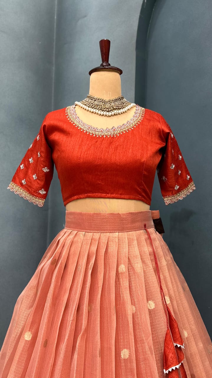 Light orange lehanga on a mannequin against a gray background