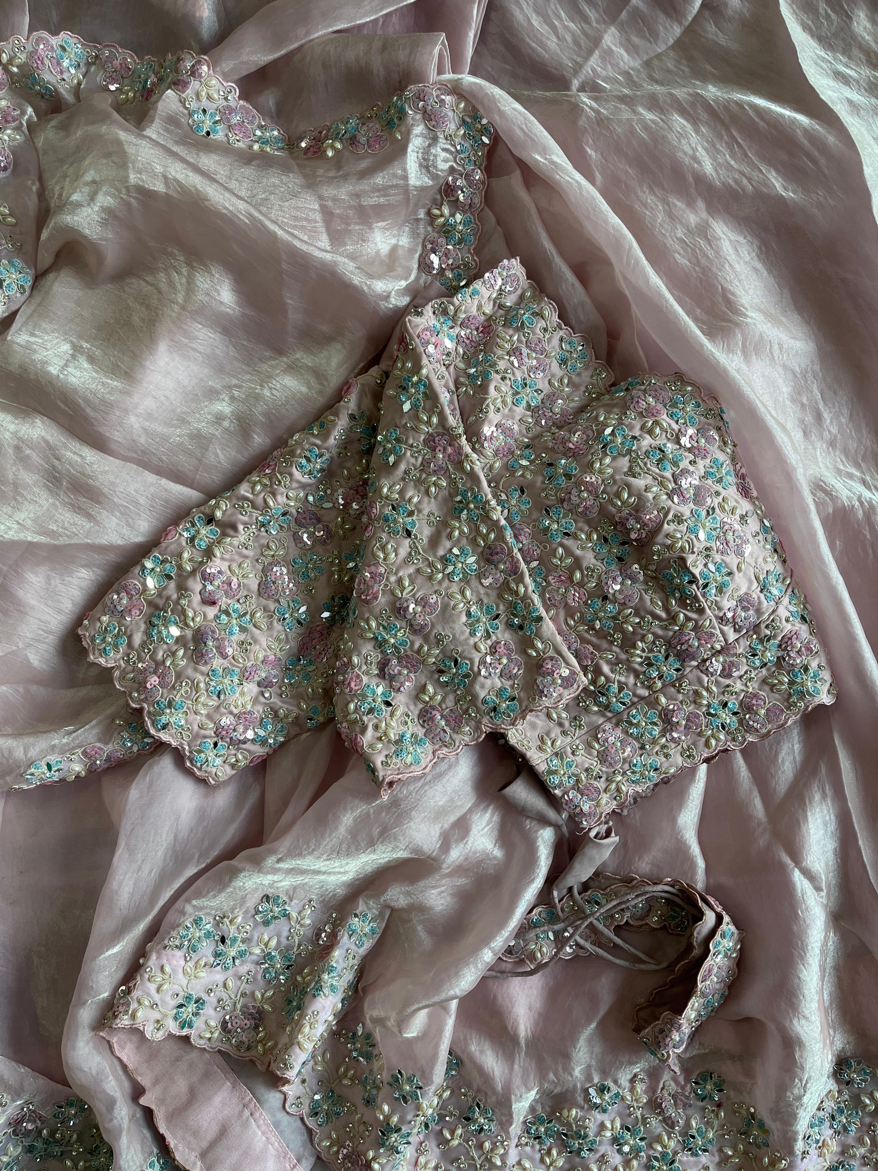 Baby pink fabric with floral embellishments on a textured fabric background