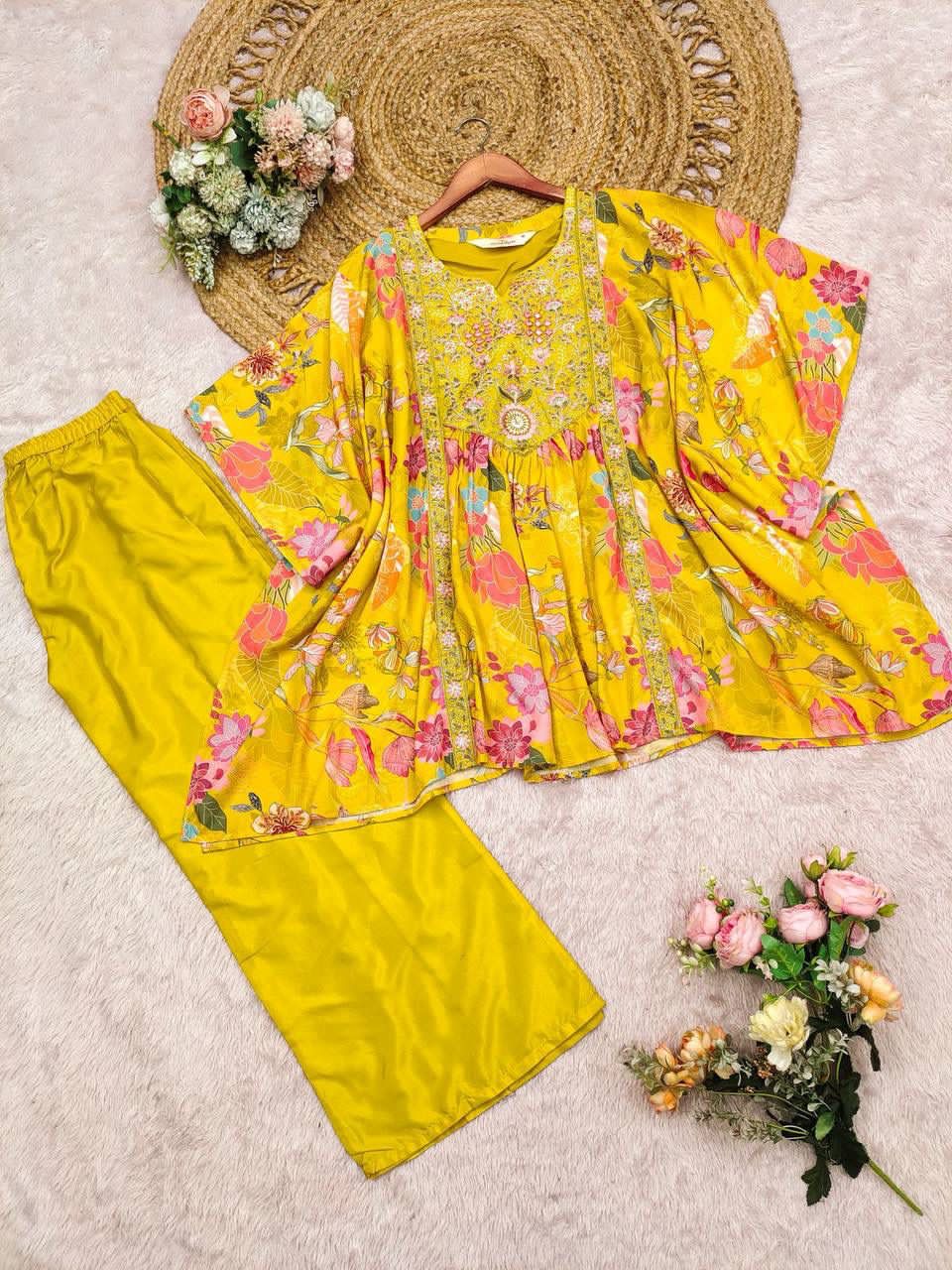 Yellow floral outfit with matching pants on a textured surface with decorative flowers.