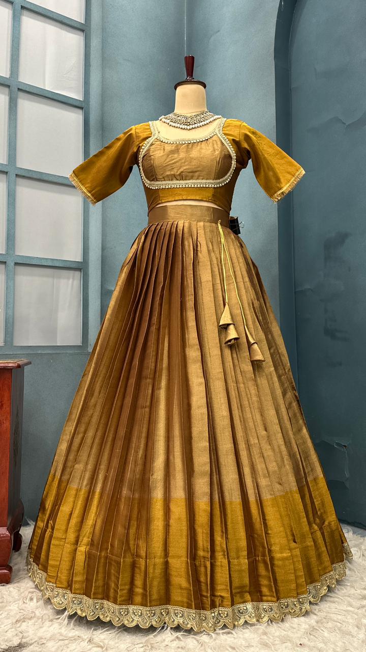 Gold and brown dress on a mannequin against a blue wall