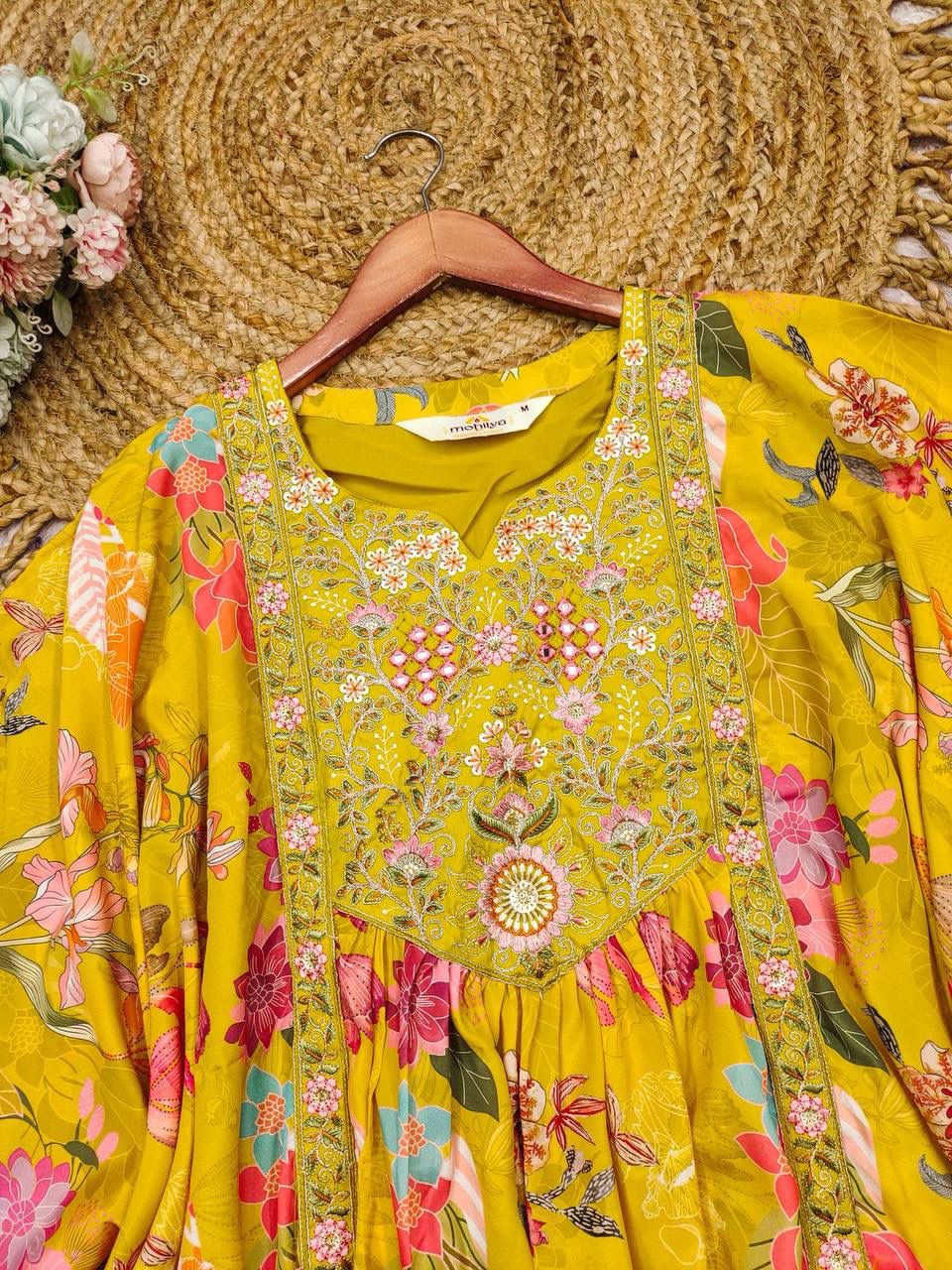 Yellow floral dress on a hanger with a woven mat and flowers in the background