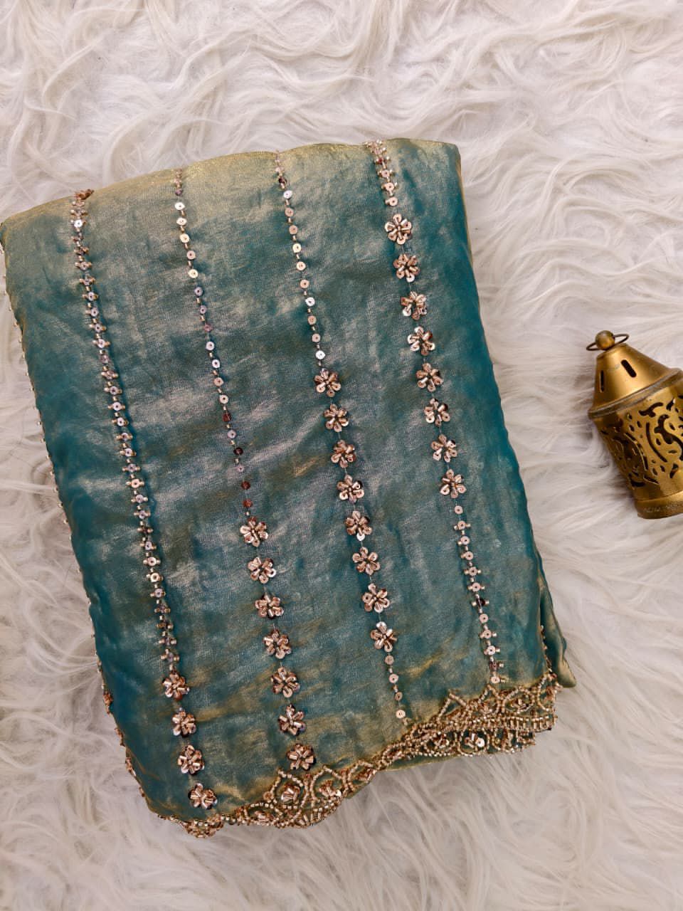 Turquoise Blue fabric with floral embroidery on a textured surface
