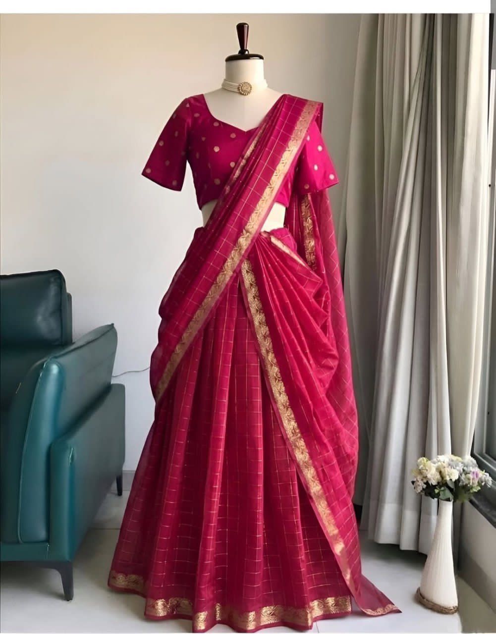 Rani pink saree with gold border on a mannequin against a neutral background