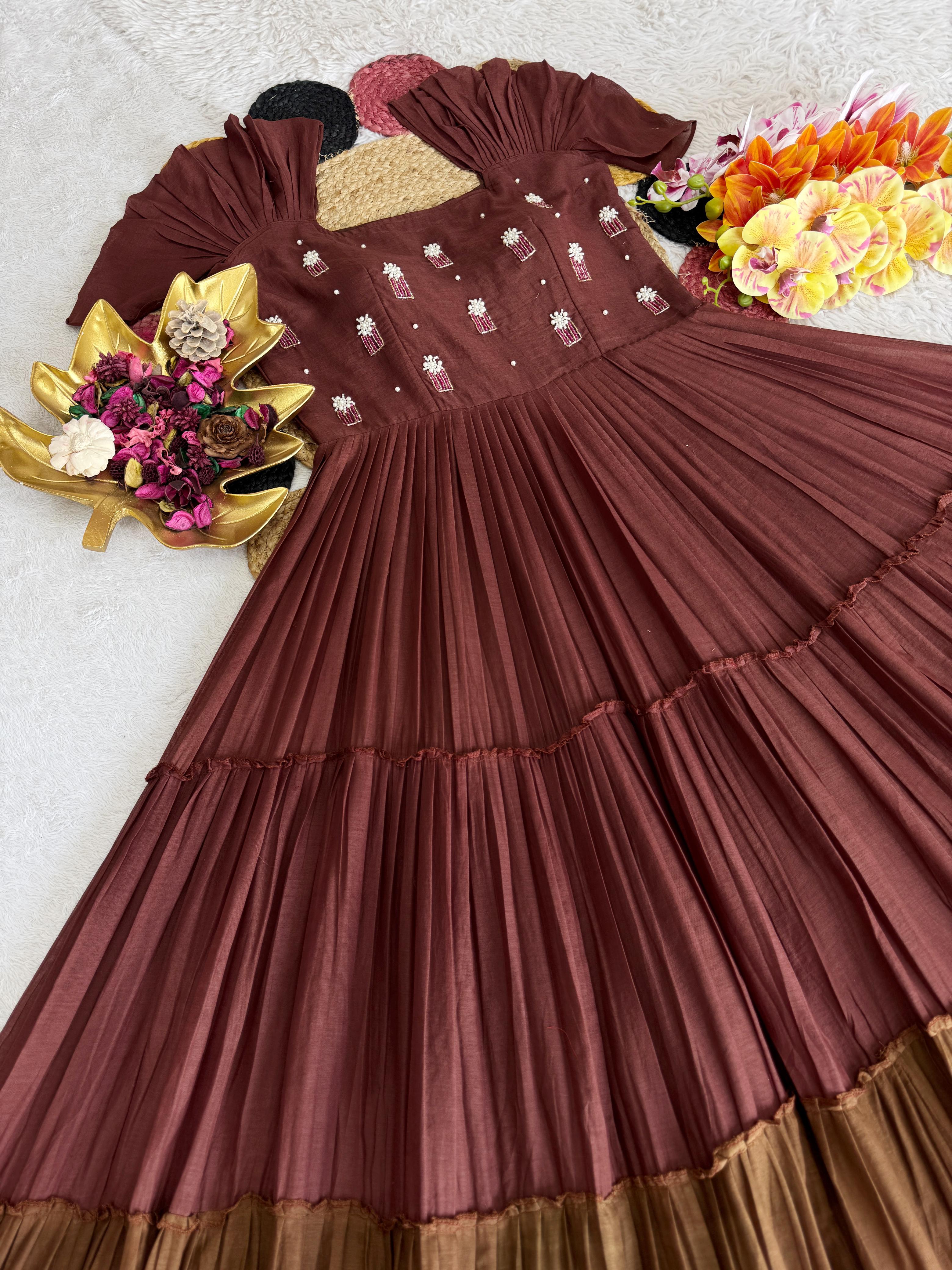 Brown pleated dress with floral embellishments on a background
